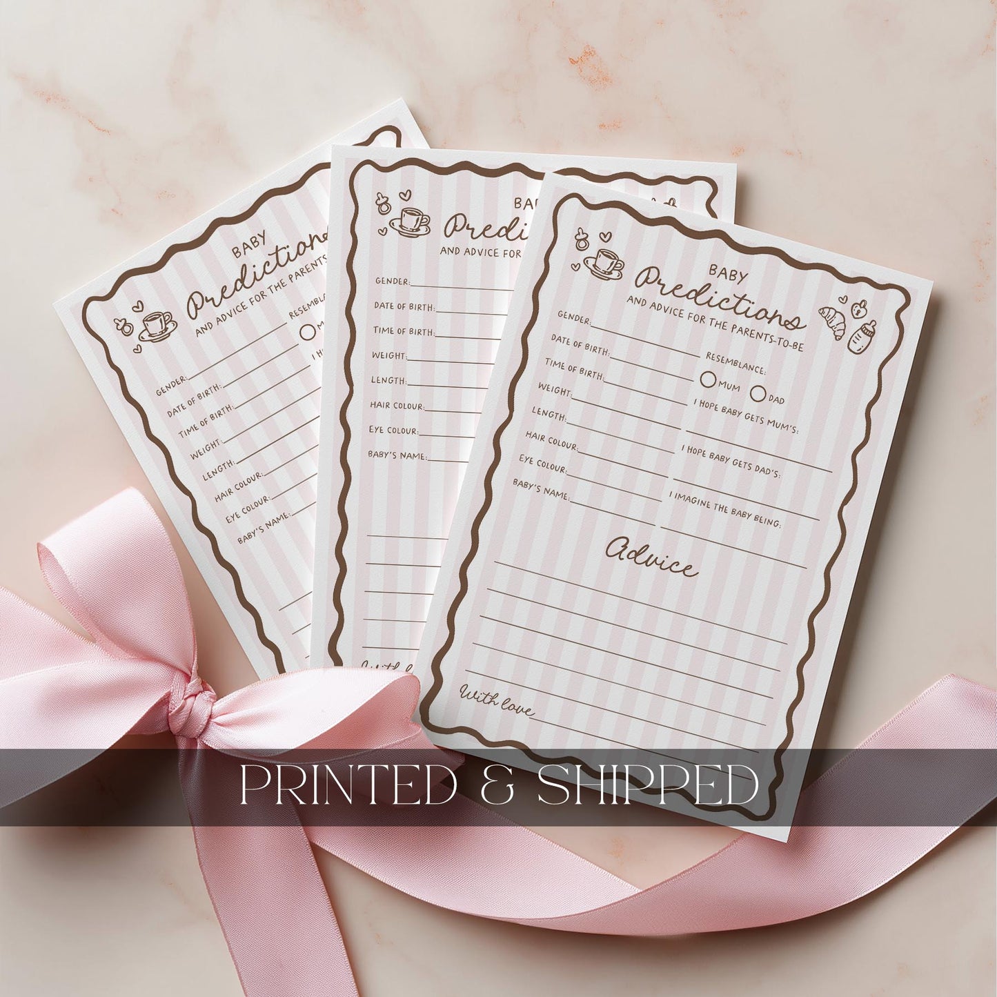 Three baby prediction and advice cards with a pink ribbon on a light background