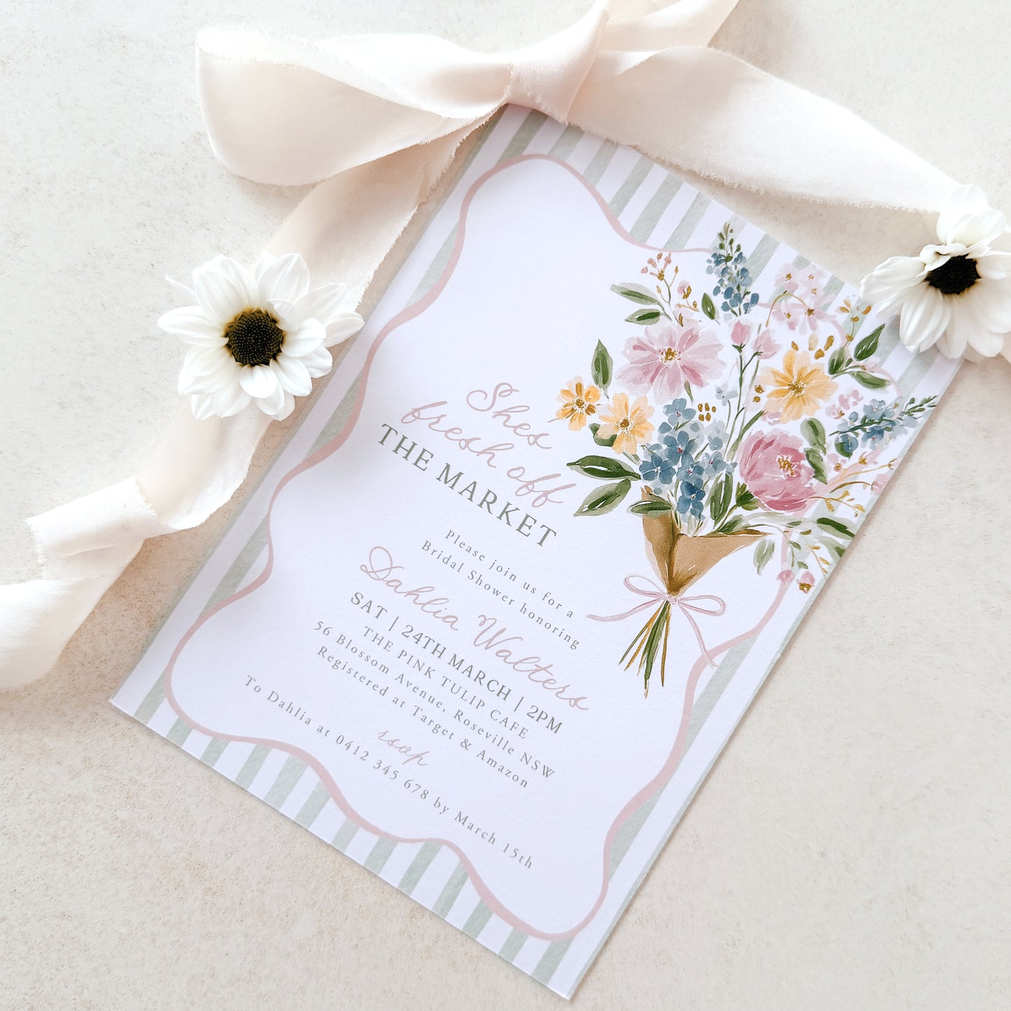 Invitation card with floral design and ribbon on a light background