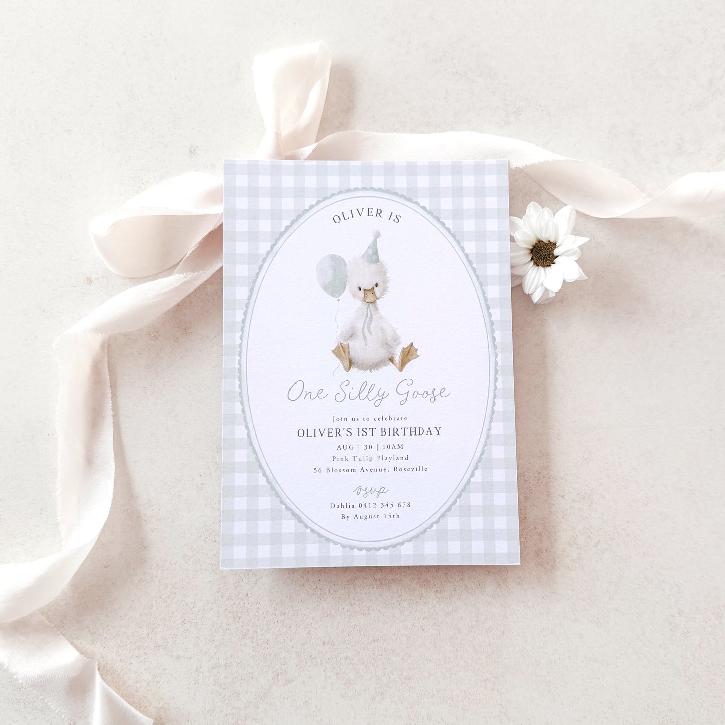 Invitation card with a baby shower theme on a light pink background with ribbons and flowers.