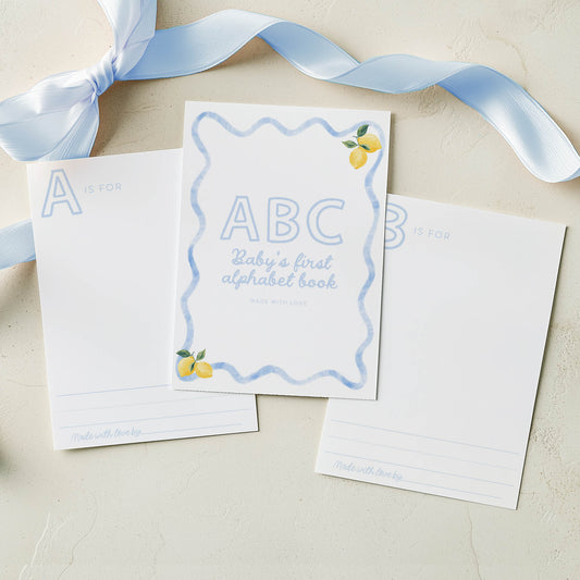 Children's book titled 'ABC Baby's first alphabet book' with a blue ribbon on a beige background