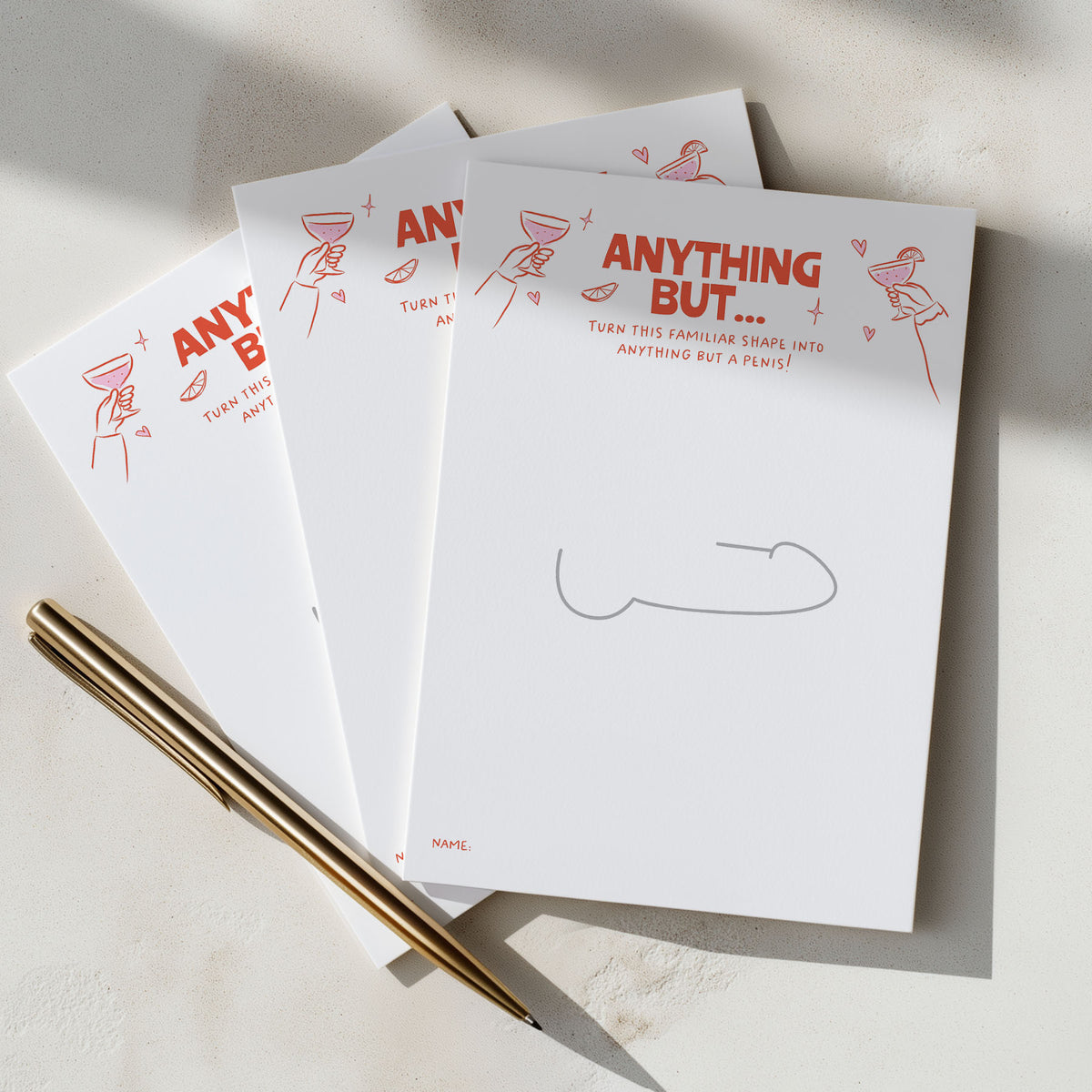 Three hens party game sheets fanned out on a light surface, printed with the phrase 'ANYTHING BUT.