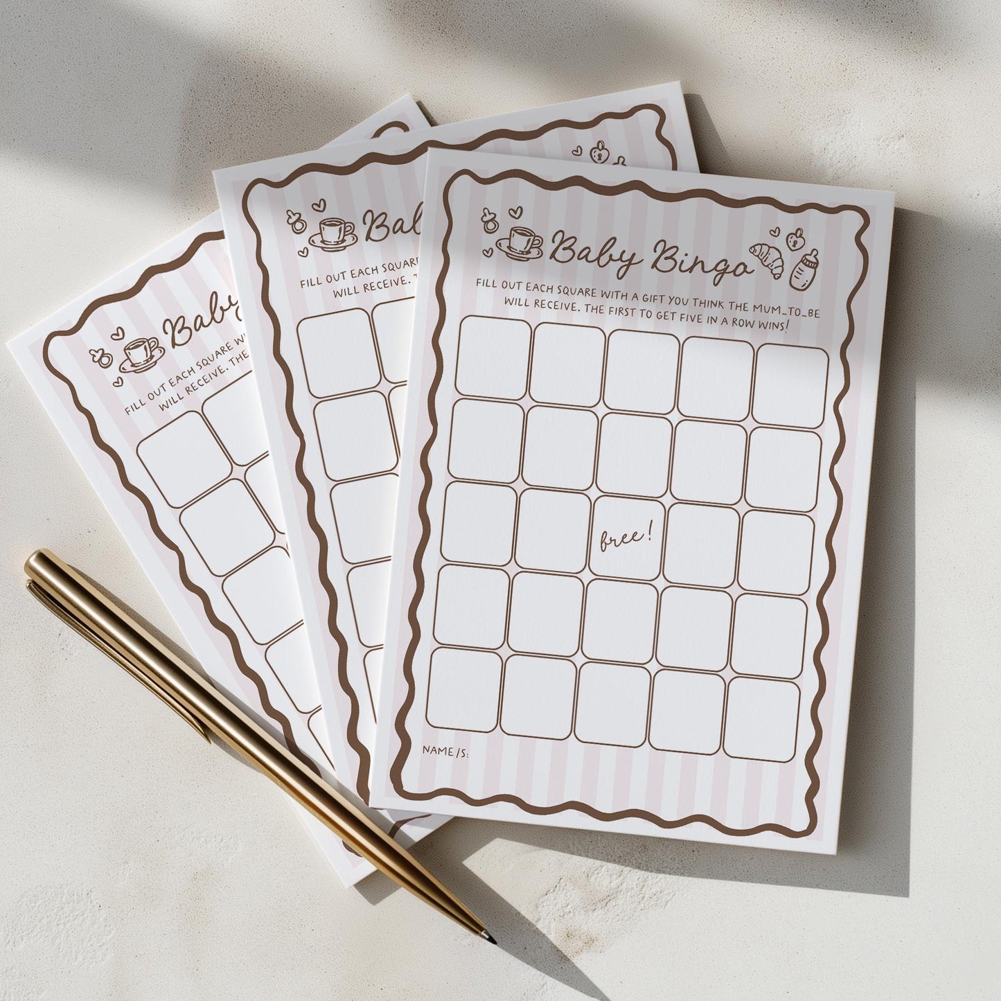 Baby shower bingo cards with a pen on a light surface