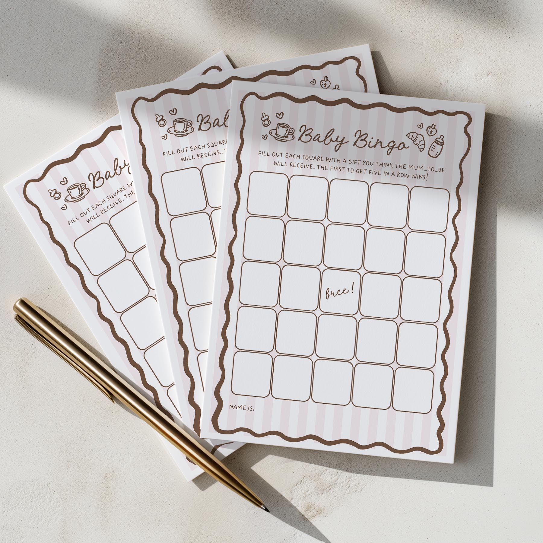 Baby shower bingo cards with a pen on a light surface