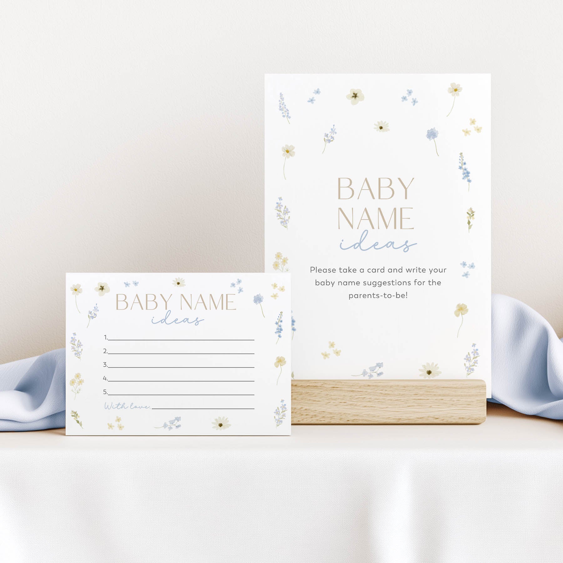 Two baby name suggestion cards with floral designs on a white surface.
