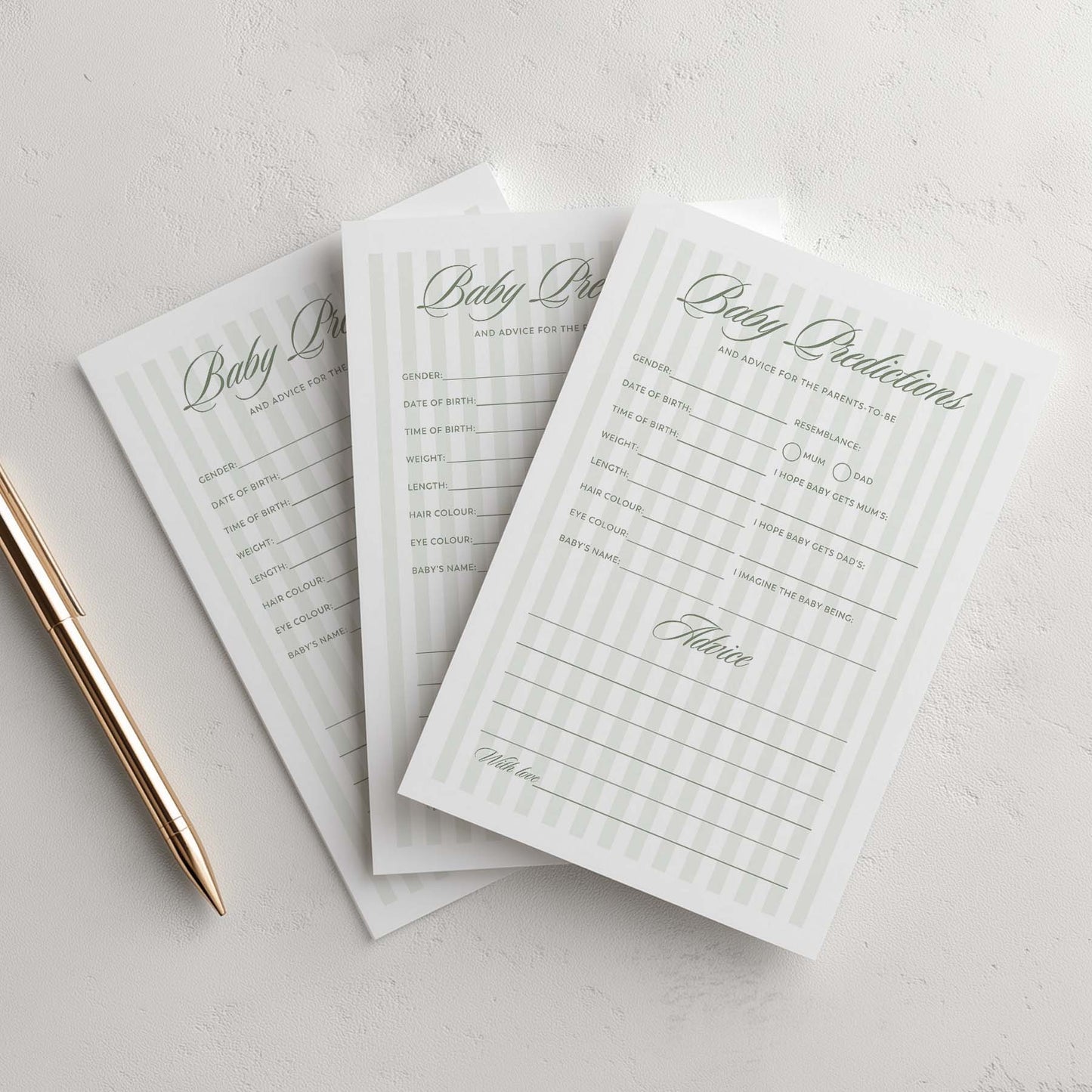 Three green stripe baby shower planning sheets on a light gray surface with a pen.