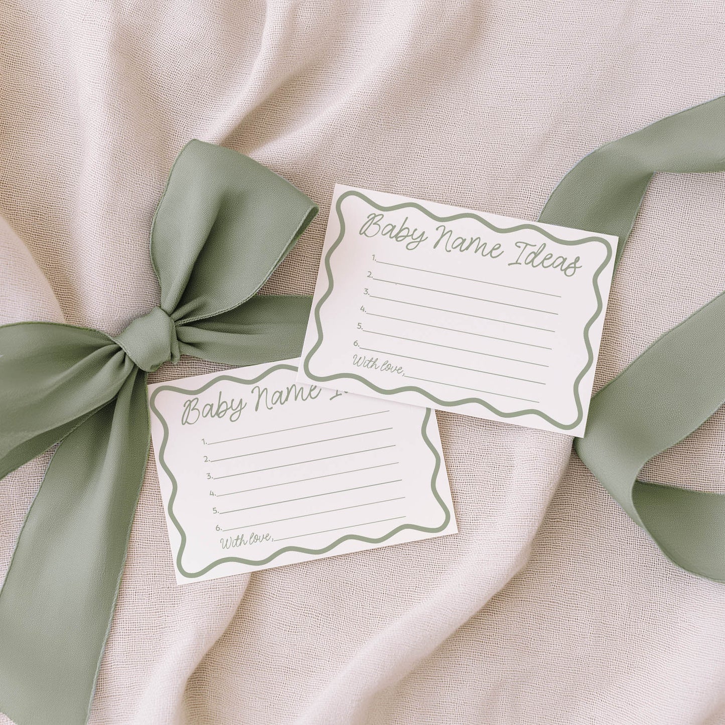 Two family tradition cards with green ribbons on a beige fabric background