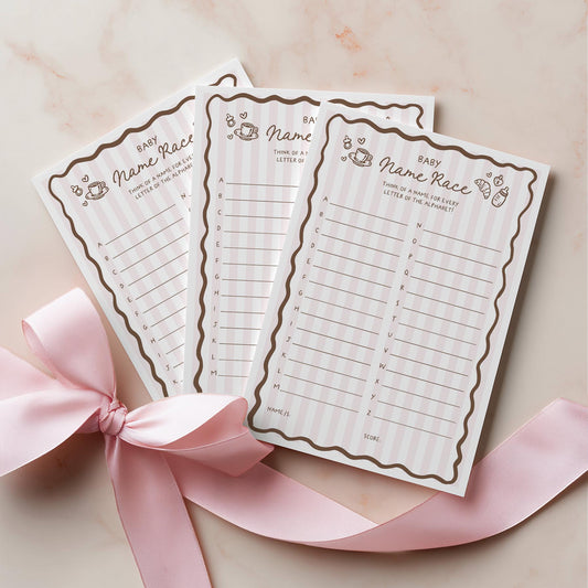 Two baby bingo cards with a pink ribbon on a light background