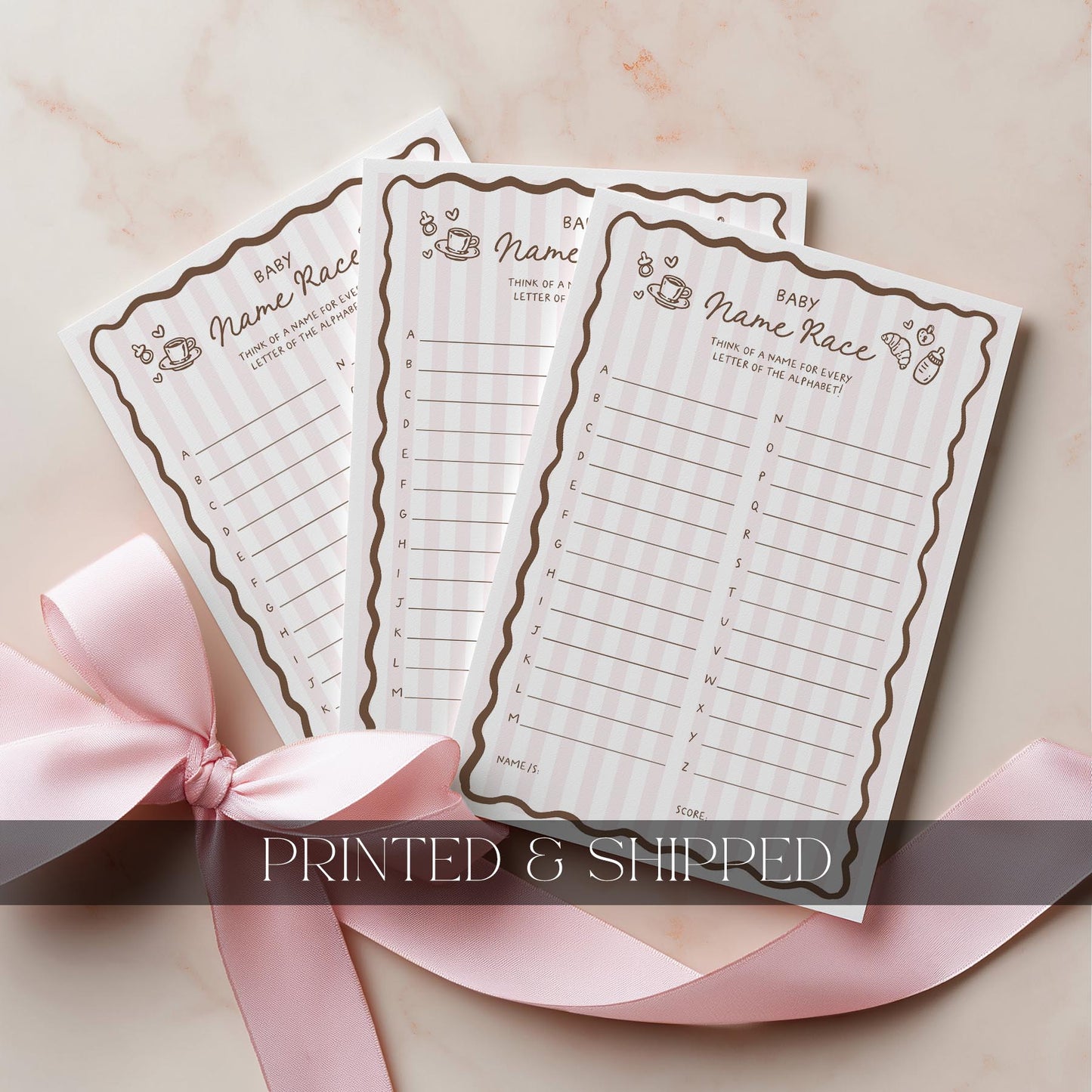 Baby shower bingo cards with a pink ribbon on a light background
