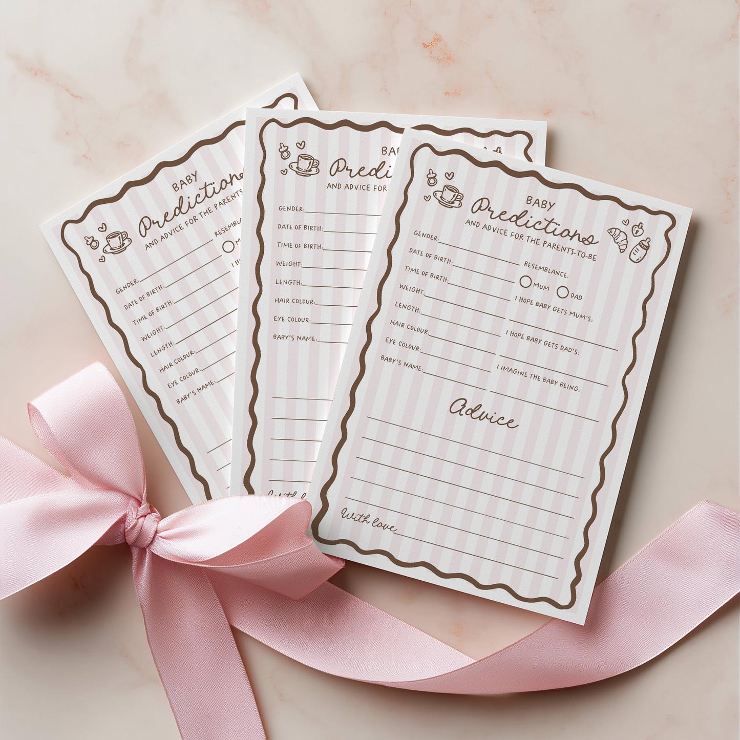 Three baby prediction and advice cards with decorative pink ribbon on a light background