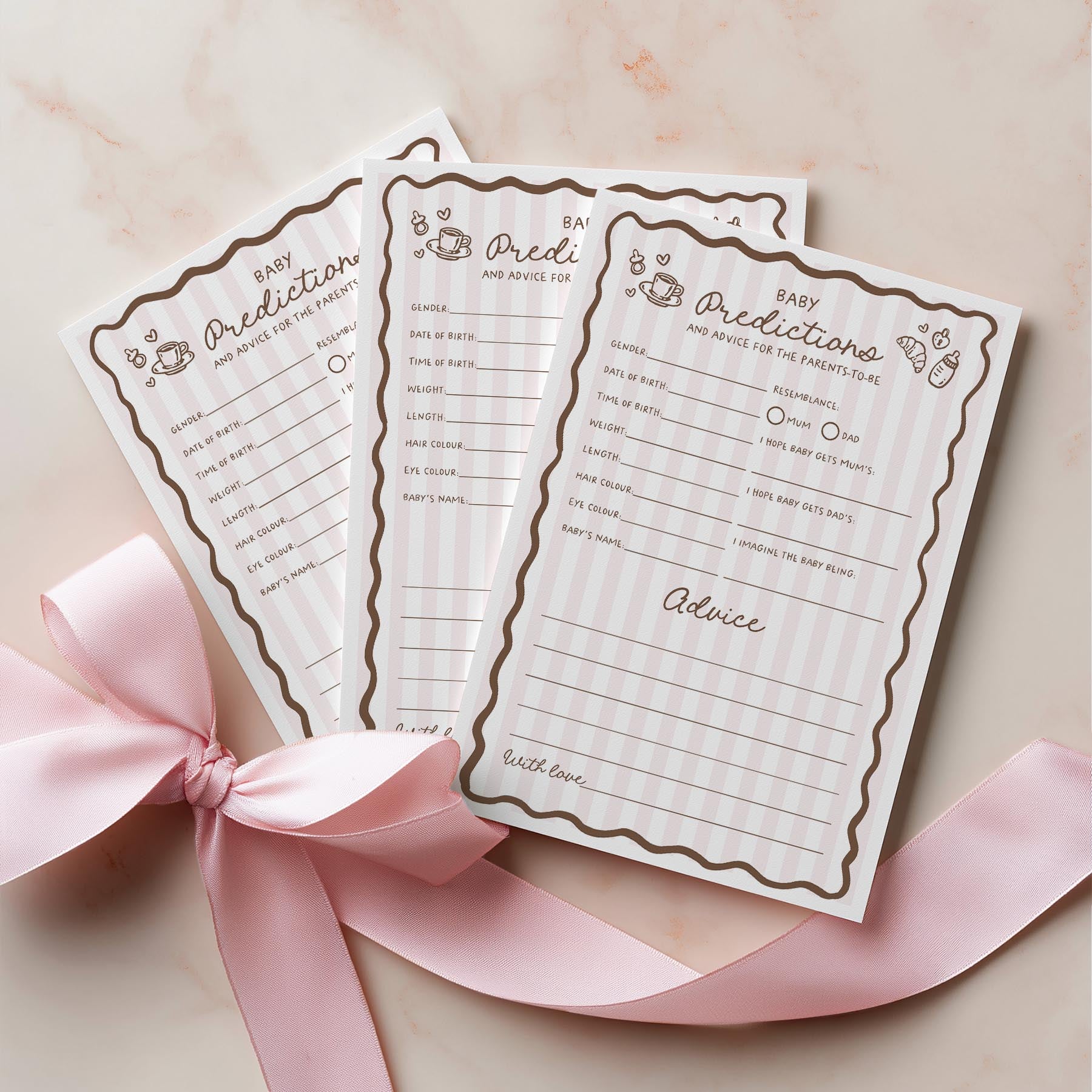 Three baby prediction and advice cards with decorative pink ribbon on a light background