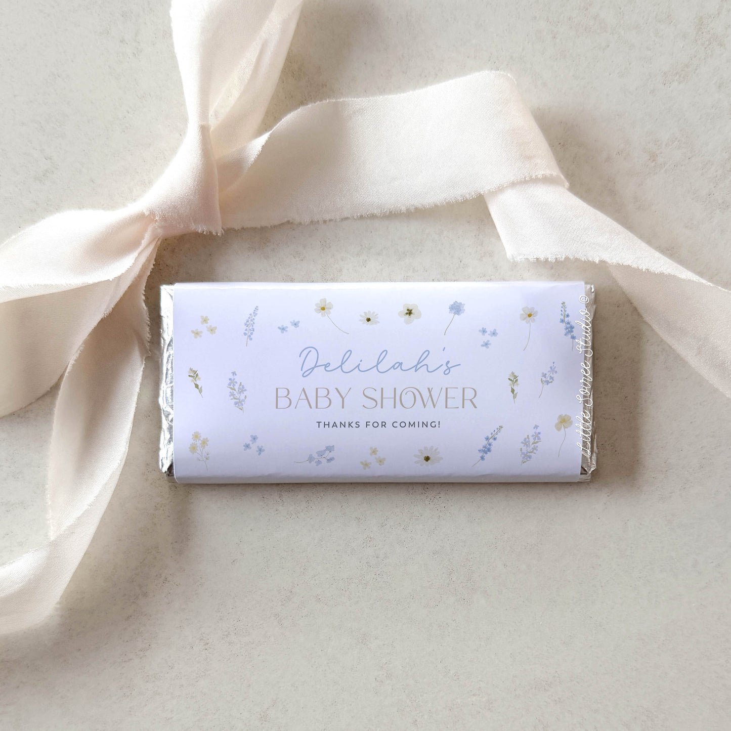 Baby shower candy bar with decorative ribbon on a light background