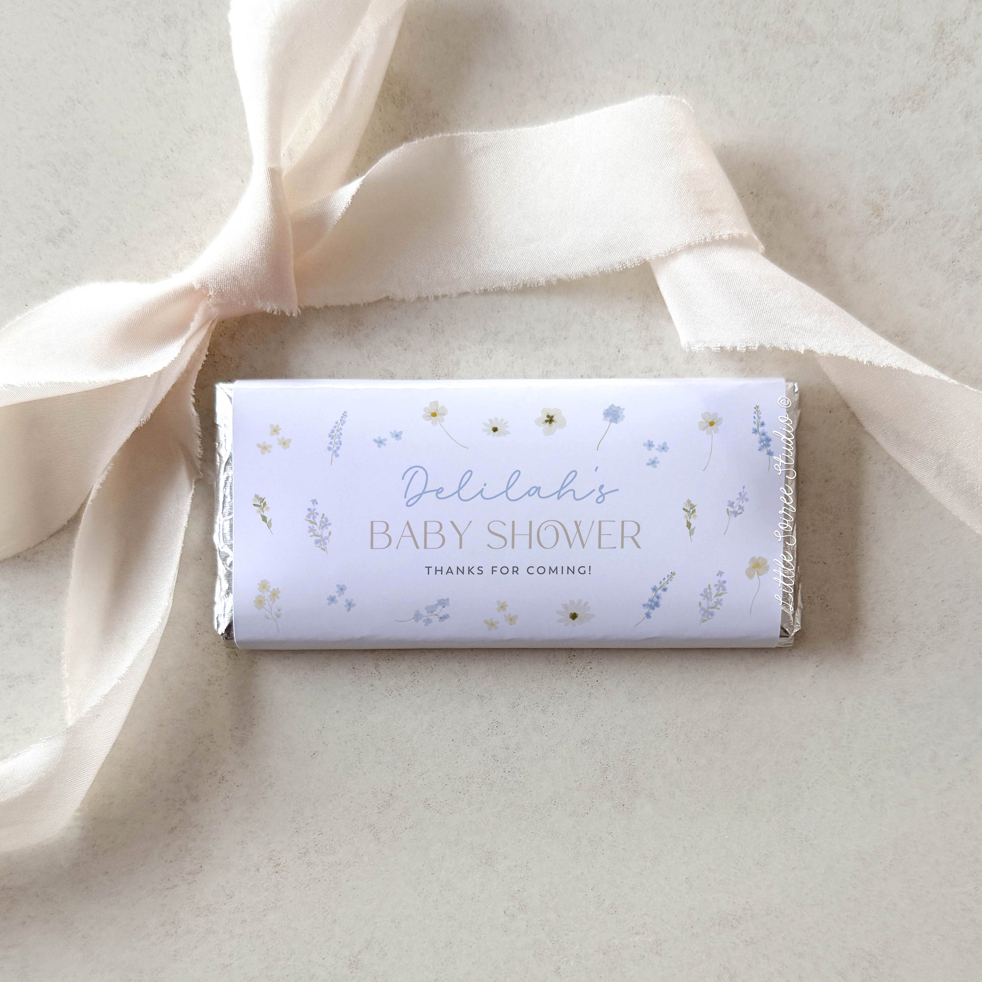 Baby shower candy bar with decorative ribbon on a light background