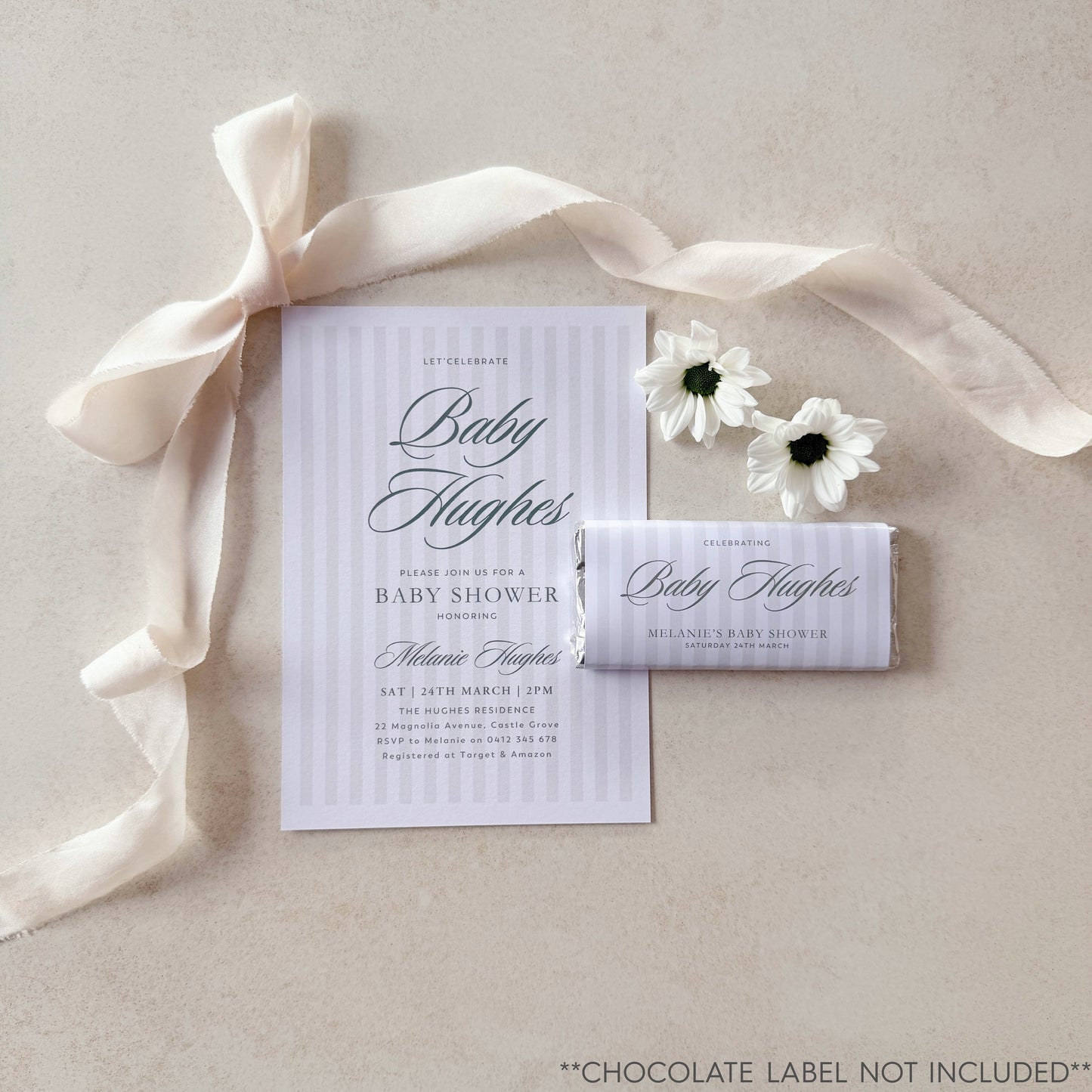 Baby shower invitation with chocolate label and ribbon on a neutral background