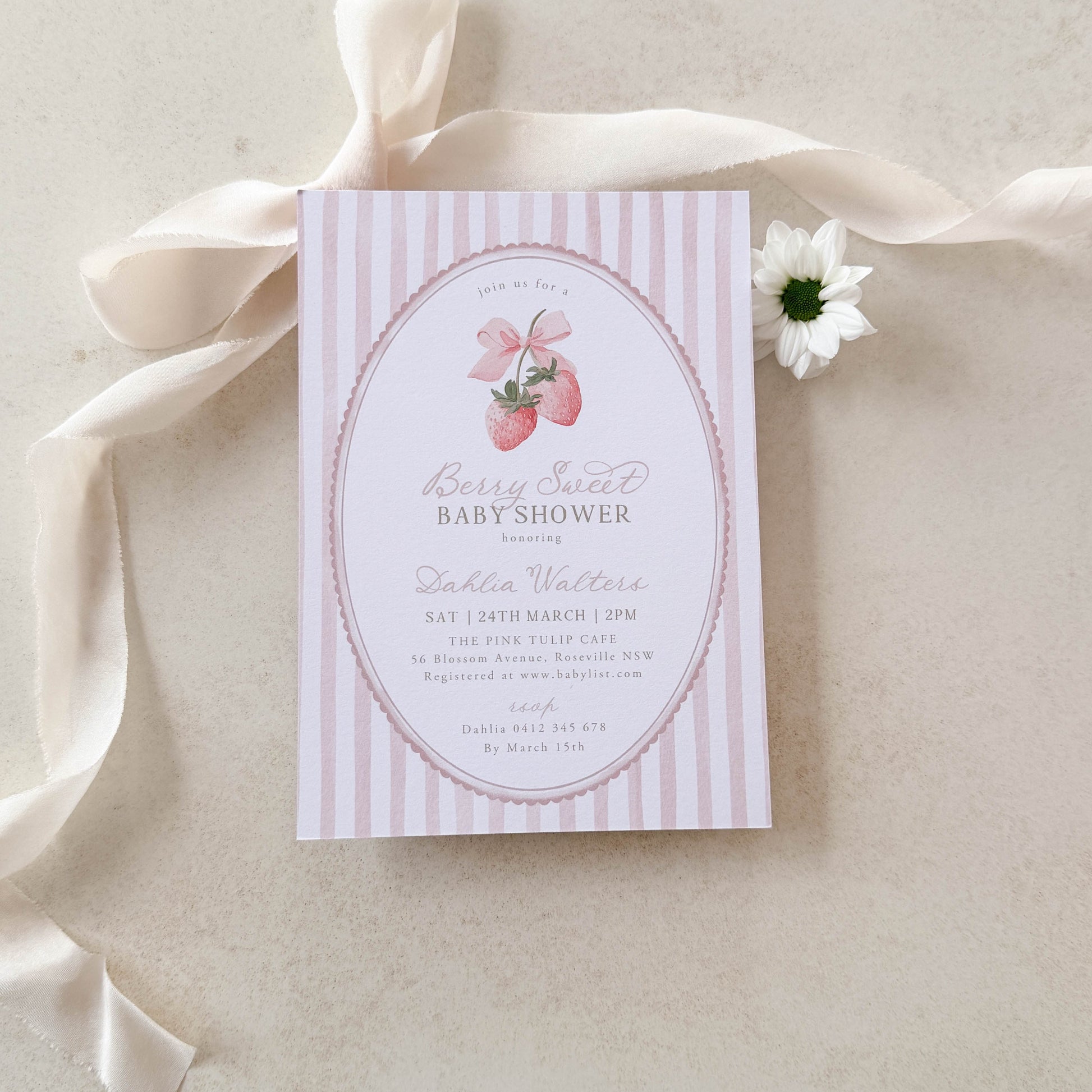 Baby shower invitation with pink and white stripes on a beige ribbon and background