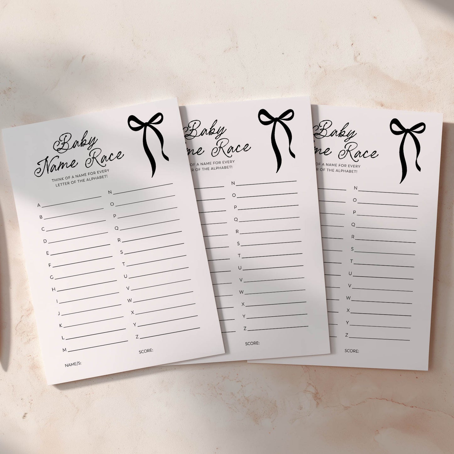 Three black bow baby predictions cards with black ribbons on a light background