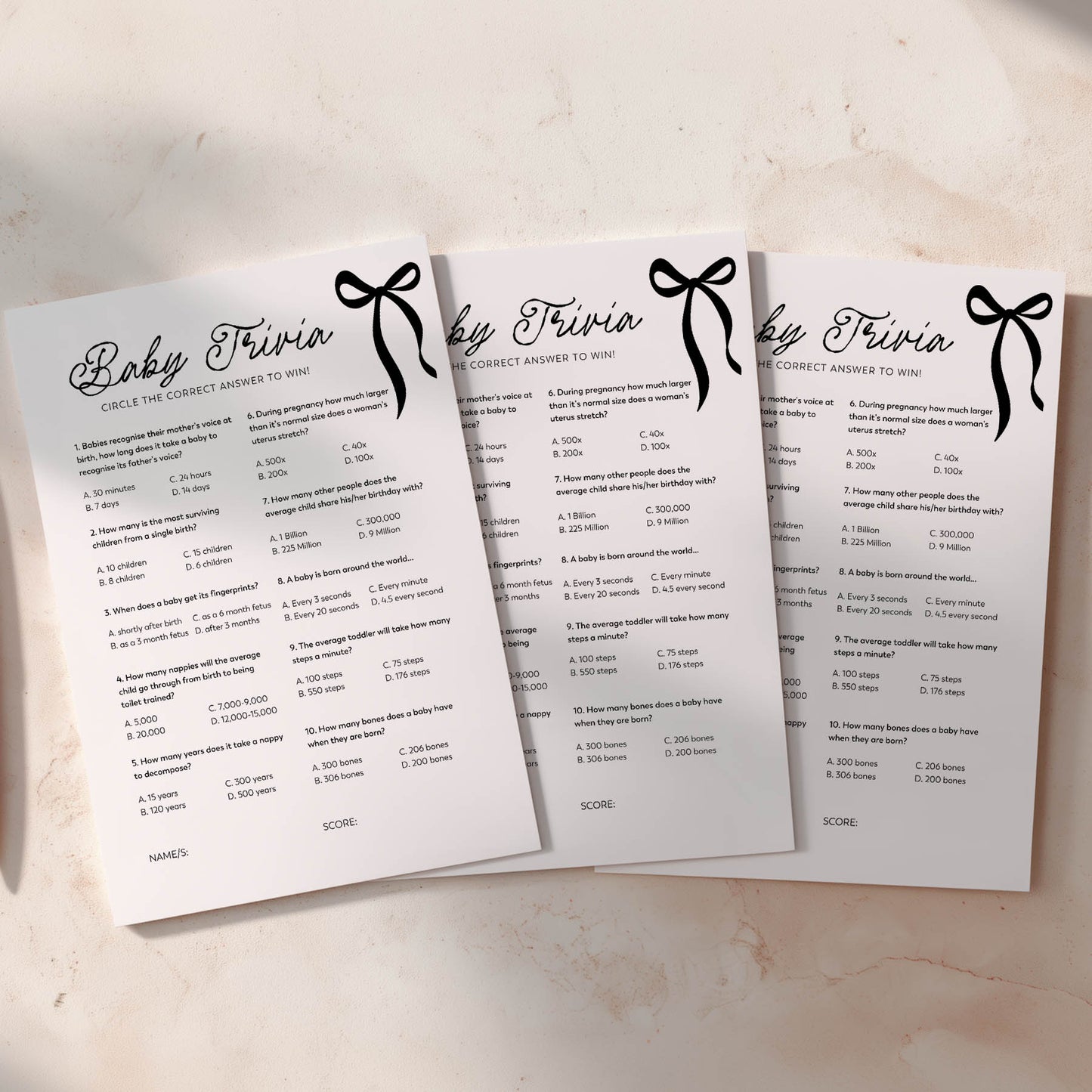 Three black bow baby trivia question cards on a light background