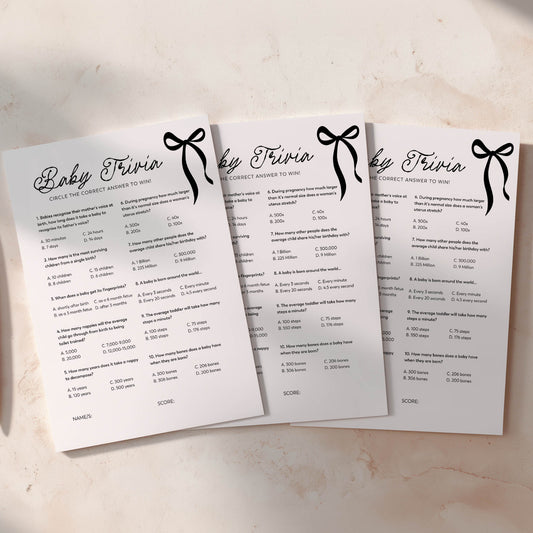 Three black bow baby trivia question cards on a light background
