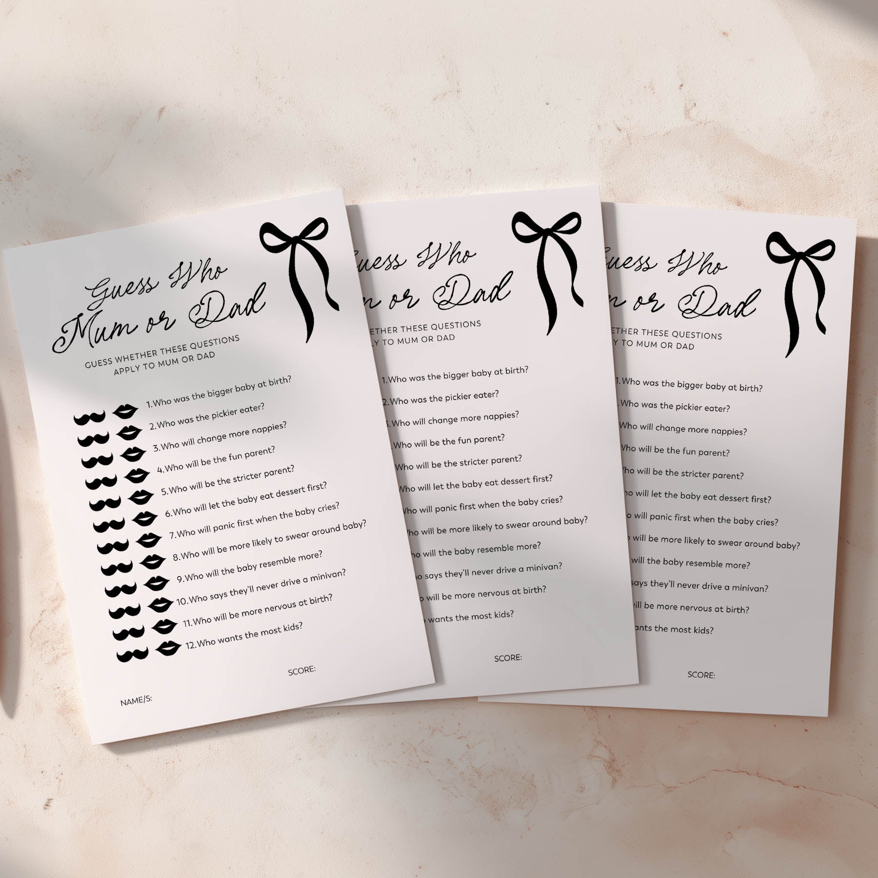 Three sheets of paper with black bow baby shower game questions on a light surface
