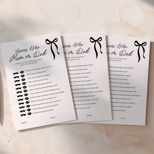 Three sheets of paper with black bow baby shower game questions on a light surface