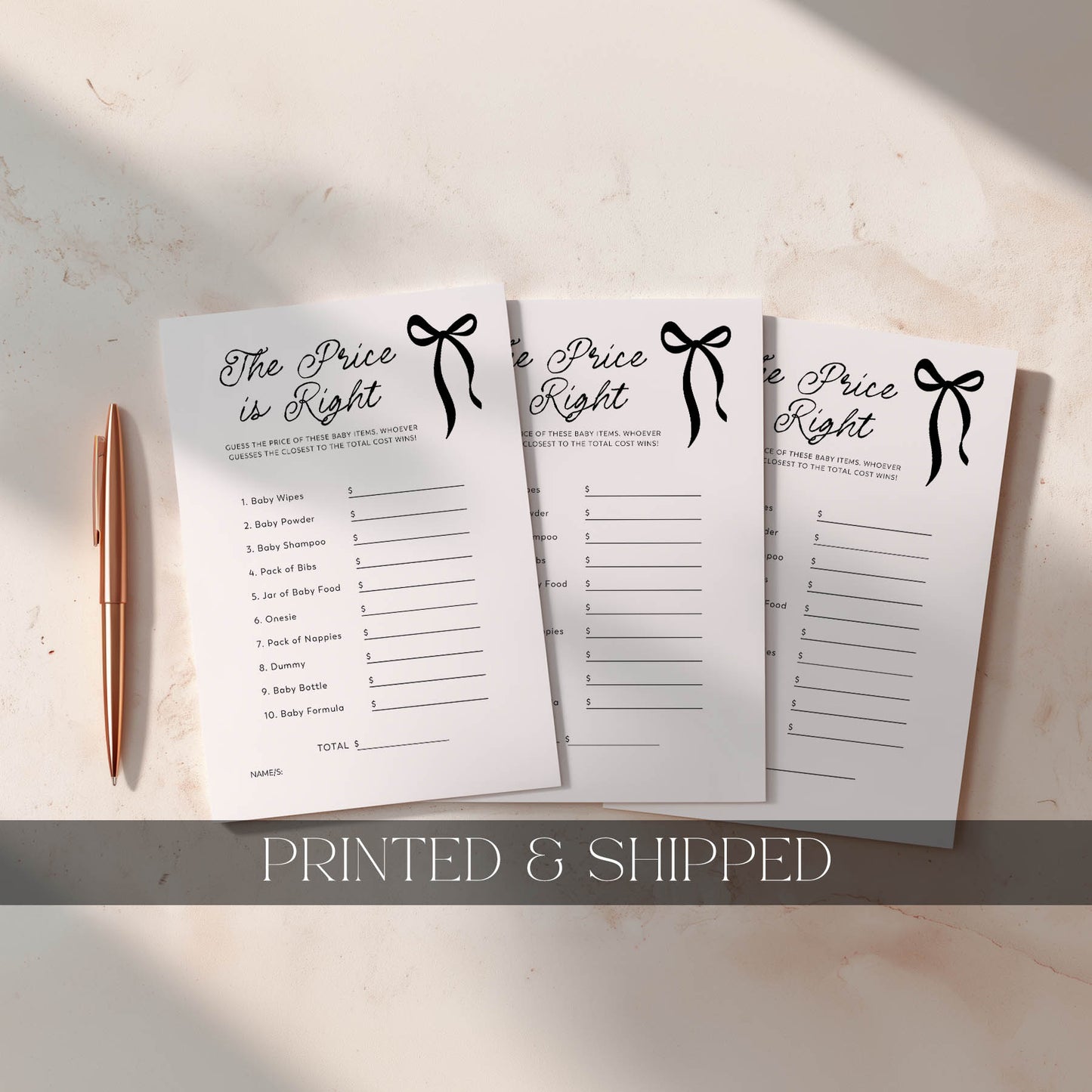 Three 'The Price is Right' baby shower game cards on a light surface with a pen.