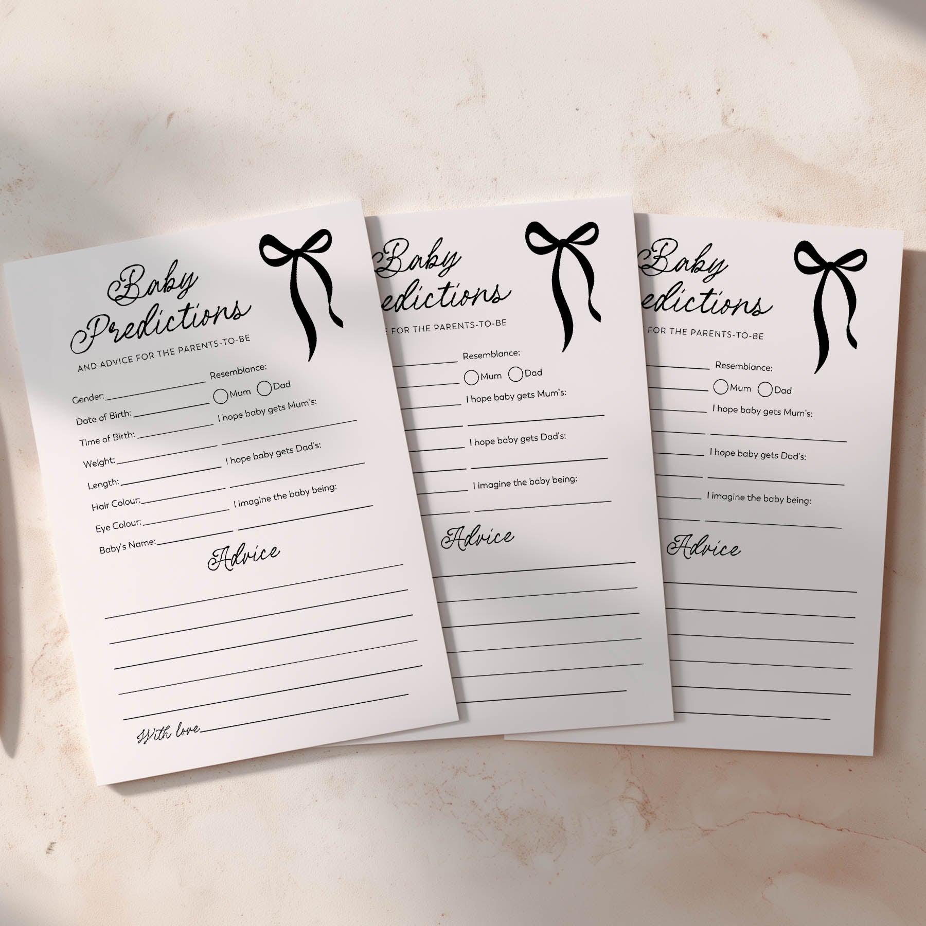 Three baby predictions cards with black bows on a light background