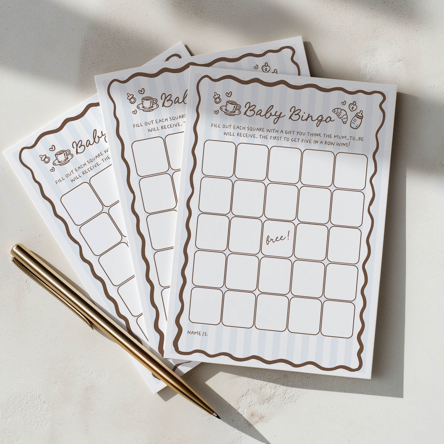 Baby shower bingo cards with a pen on a light surface