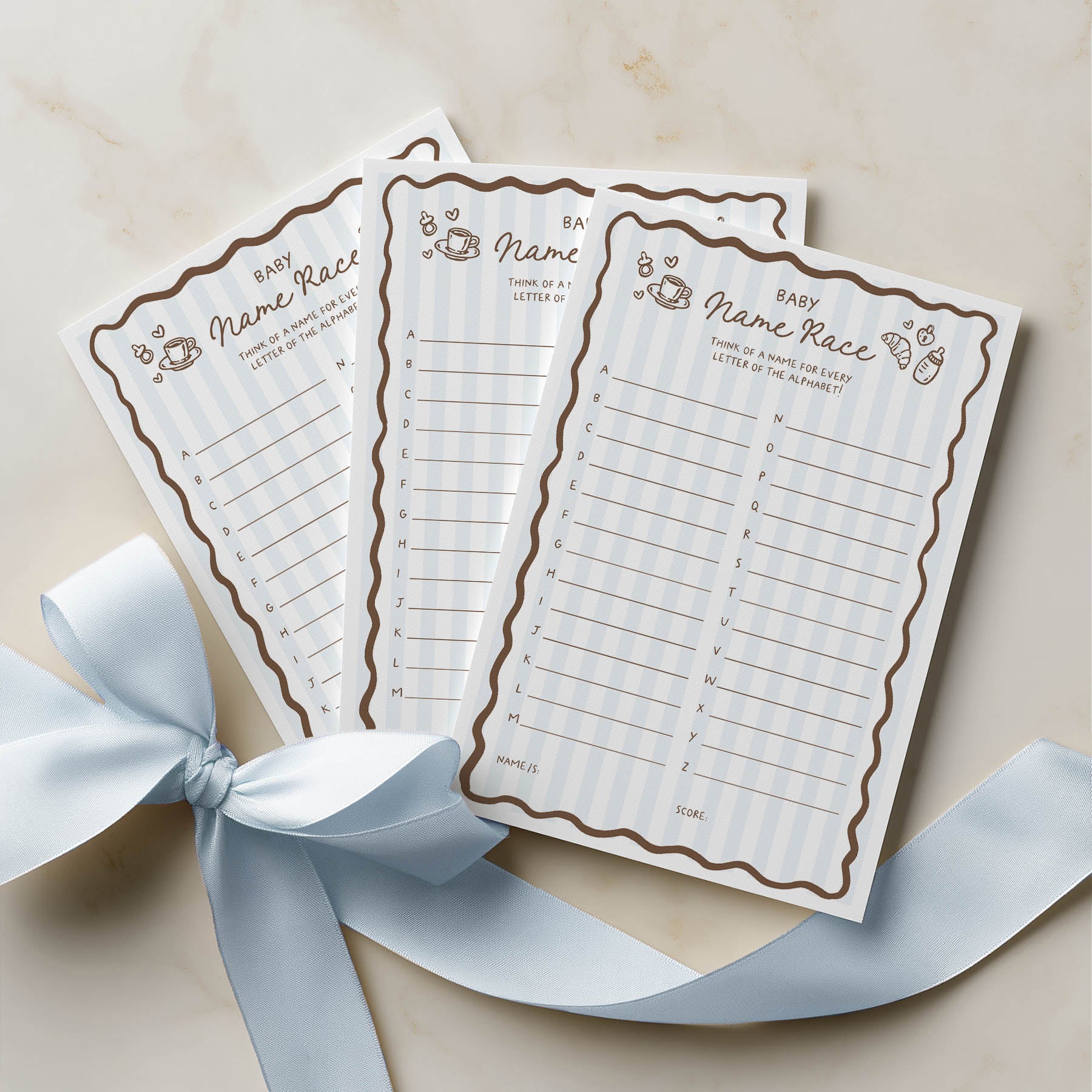 Three baby name race sheets with decorative border on a beige background with a blue ribbon.