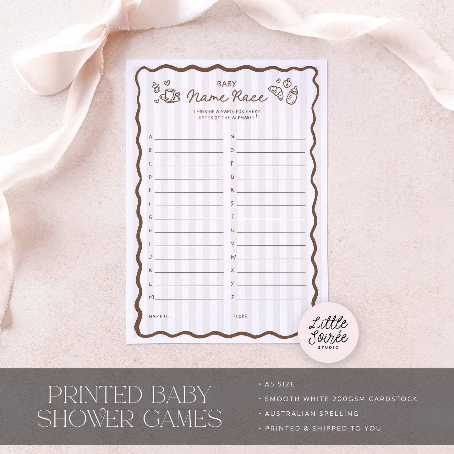 Baby shower game sheet on a light pink fabric background with 'Little Sourie Studio' branding.
