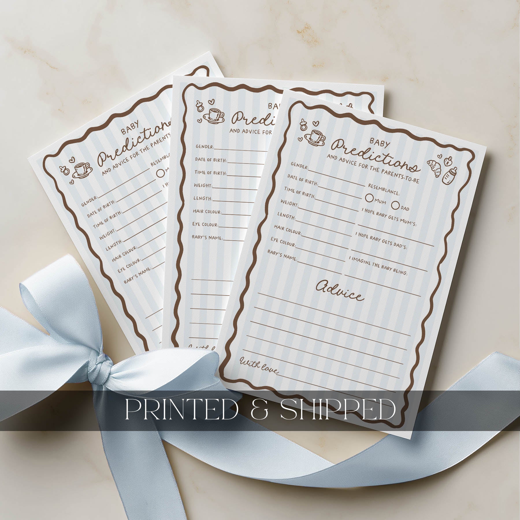 Three baby prediction and advice cards with decorative ribbon on a beige background
