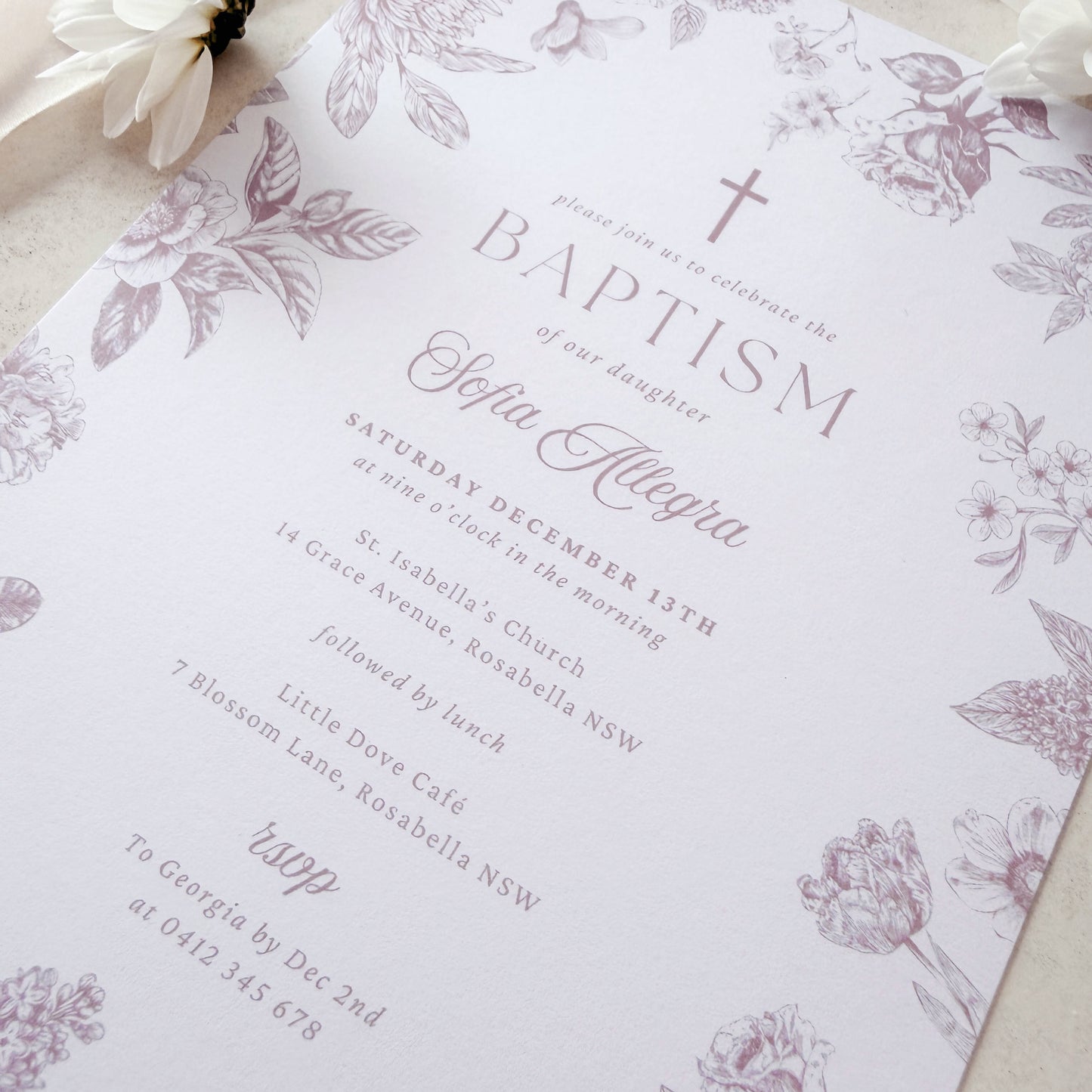 Floral invitation card on a soft beige background with ribbons and flowers.