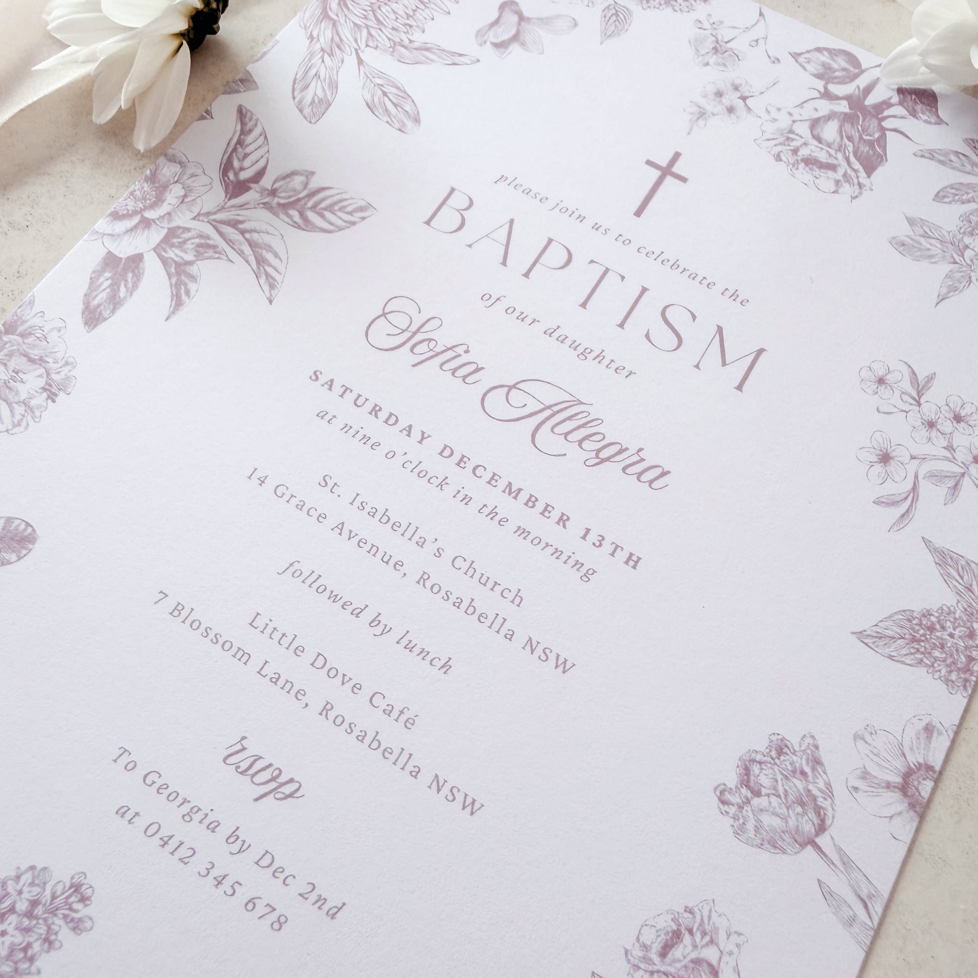 Floral invitation card on a soft beige background with ribbons and flowers.
