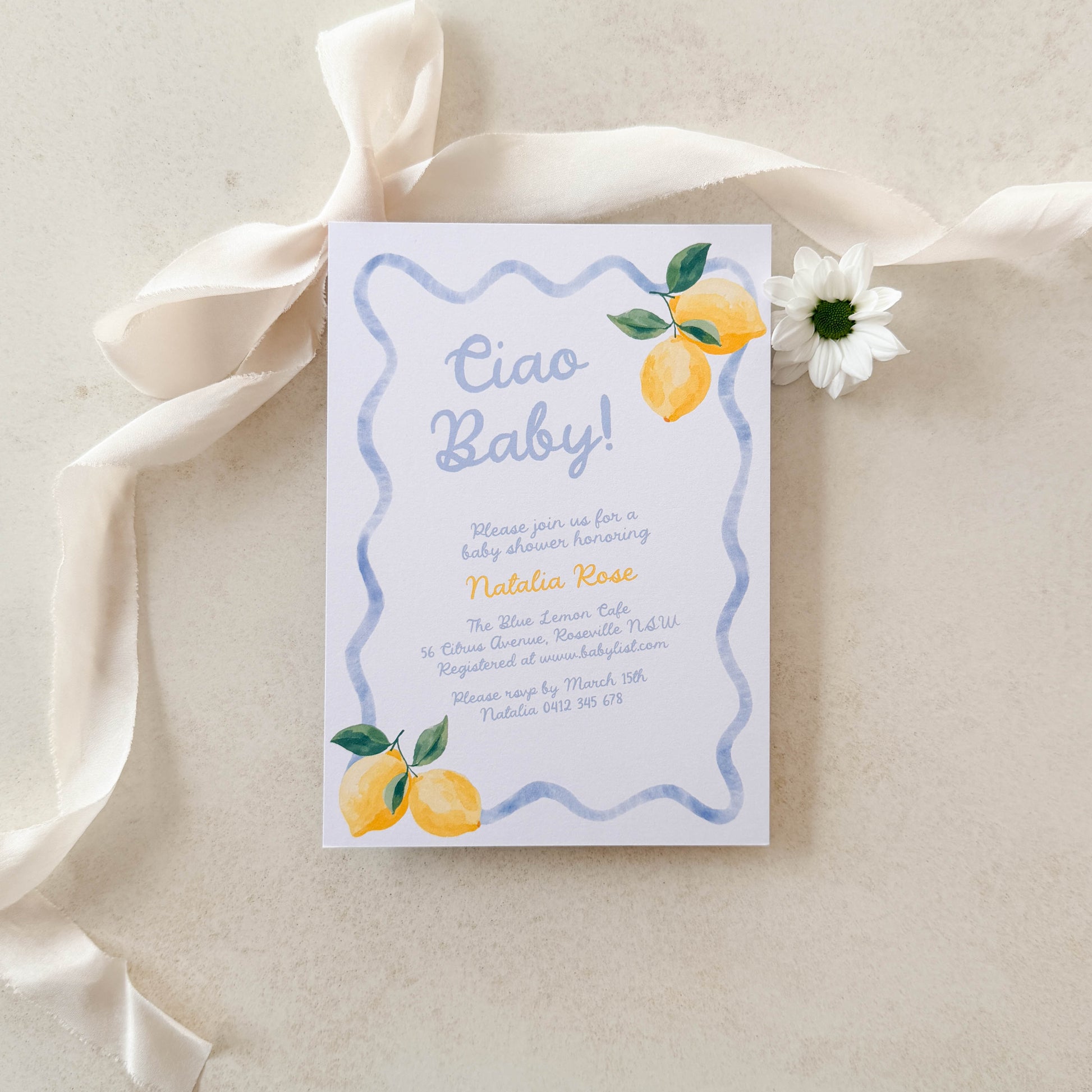 Baby shower invitation with lemons and a ribbon on a light background
