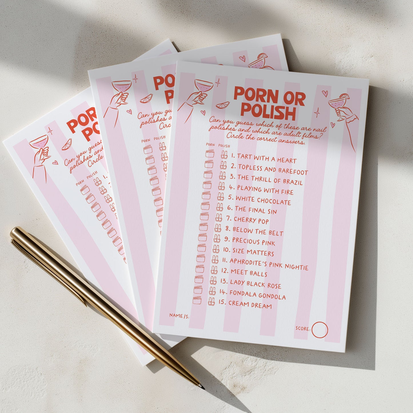 Three pink and white 'Porn or Polish' checklist cards fanned out on a light surface with two gold pens, photographed in soft natural light.