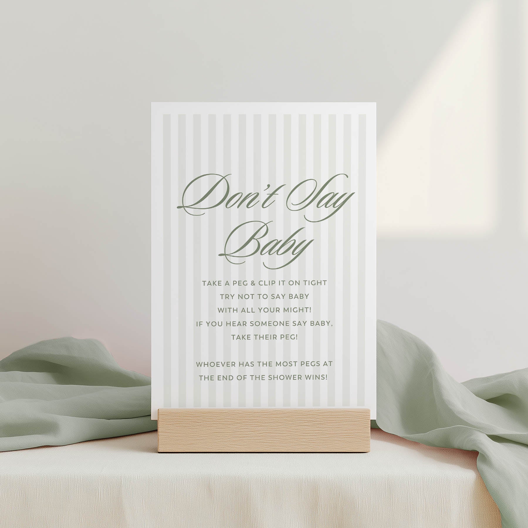 Baby shower game sign with text on a stand against a light background