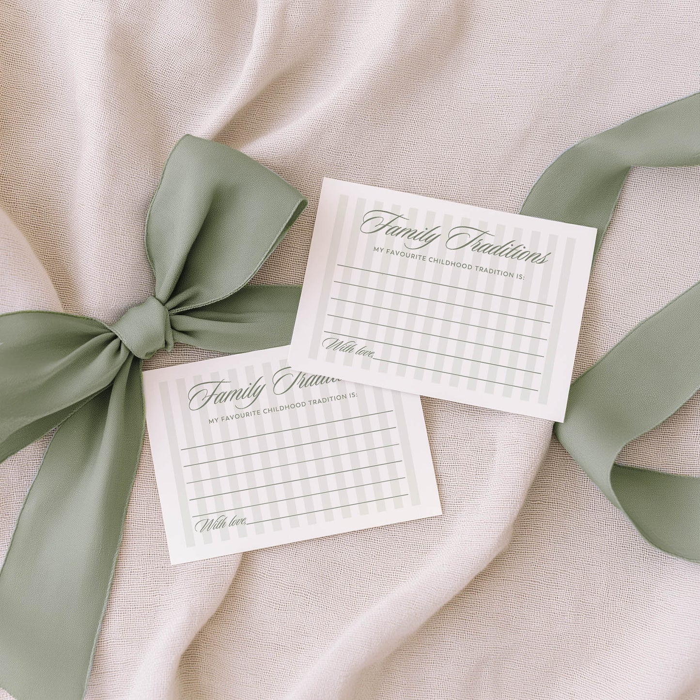 Two 'Guess the Baby Food' cards with green ribbons on a beige fabric background
