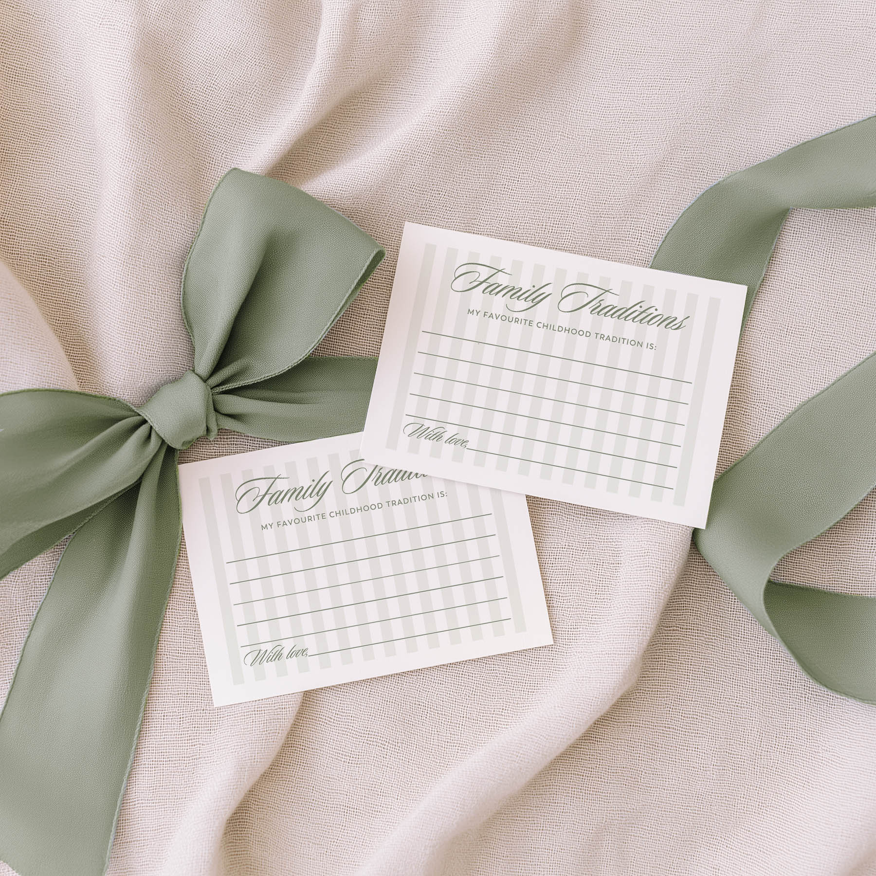 Two 'Guess the Baby Food' cards with green ribbons on a beige fabric background