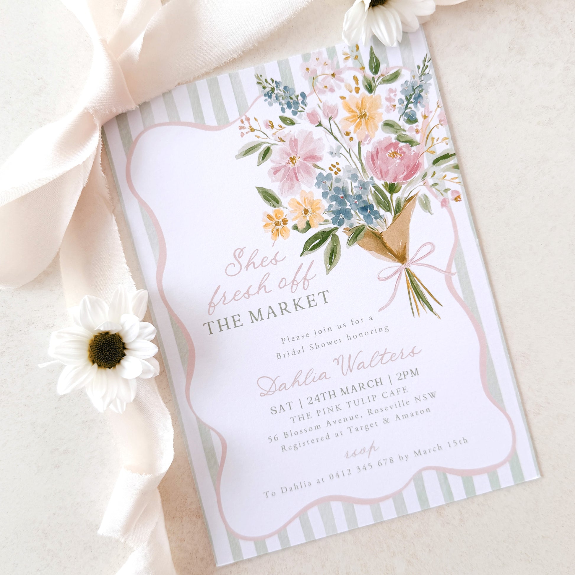 Floral bridal shower invitation with ribbon and flower on a light background