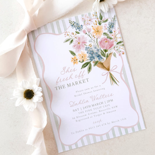 Floral bridal shower invitation with ribbon and flower on a light background