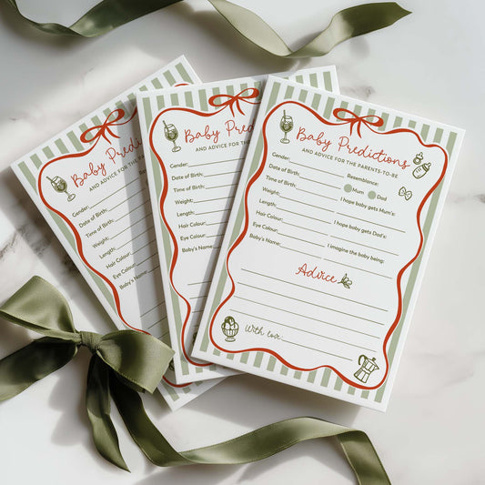 Three baby shower green striped red bow prediction cards on a light surface with a pen.