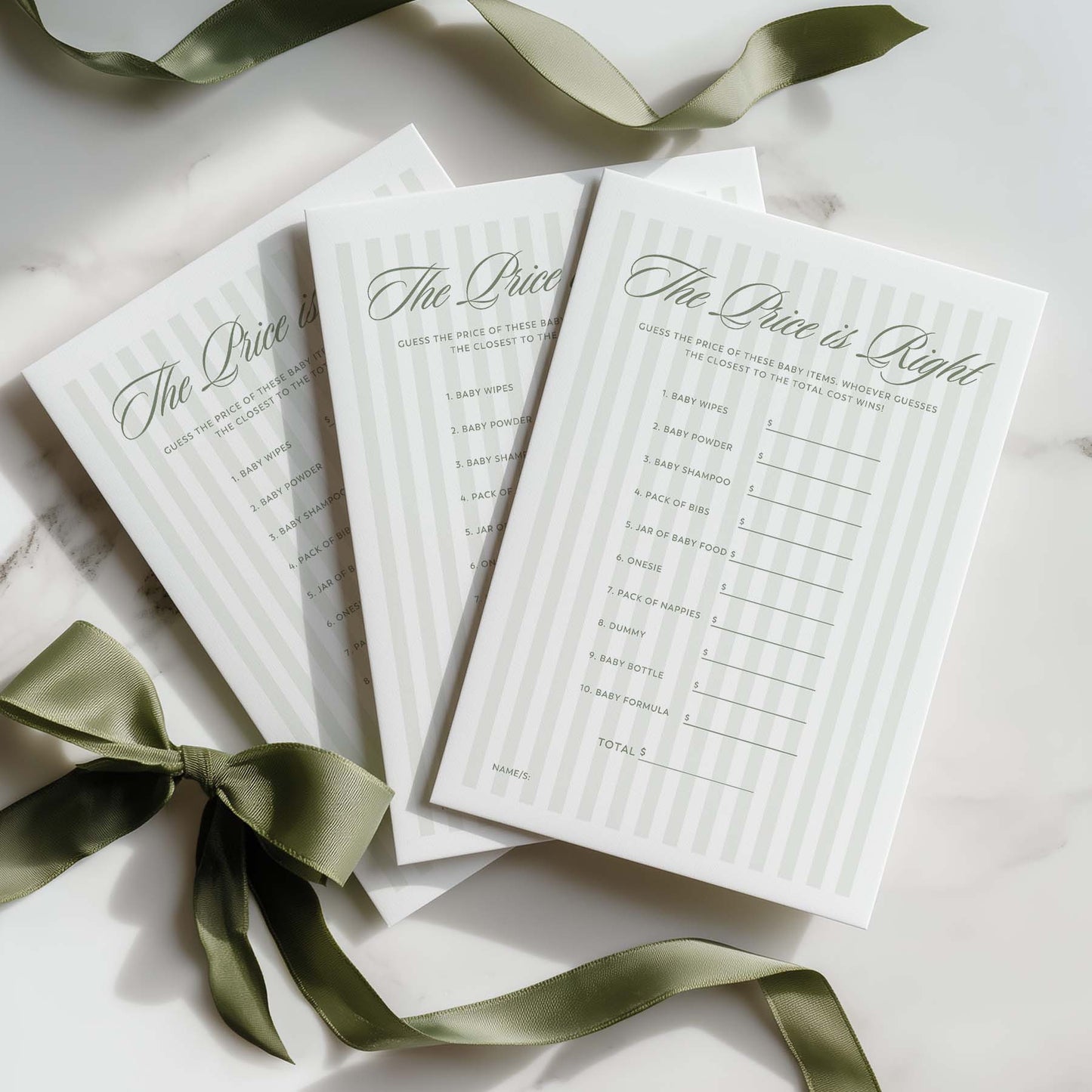 Three green stripe baby name lists on a marble surface with green ribbons.