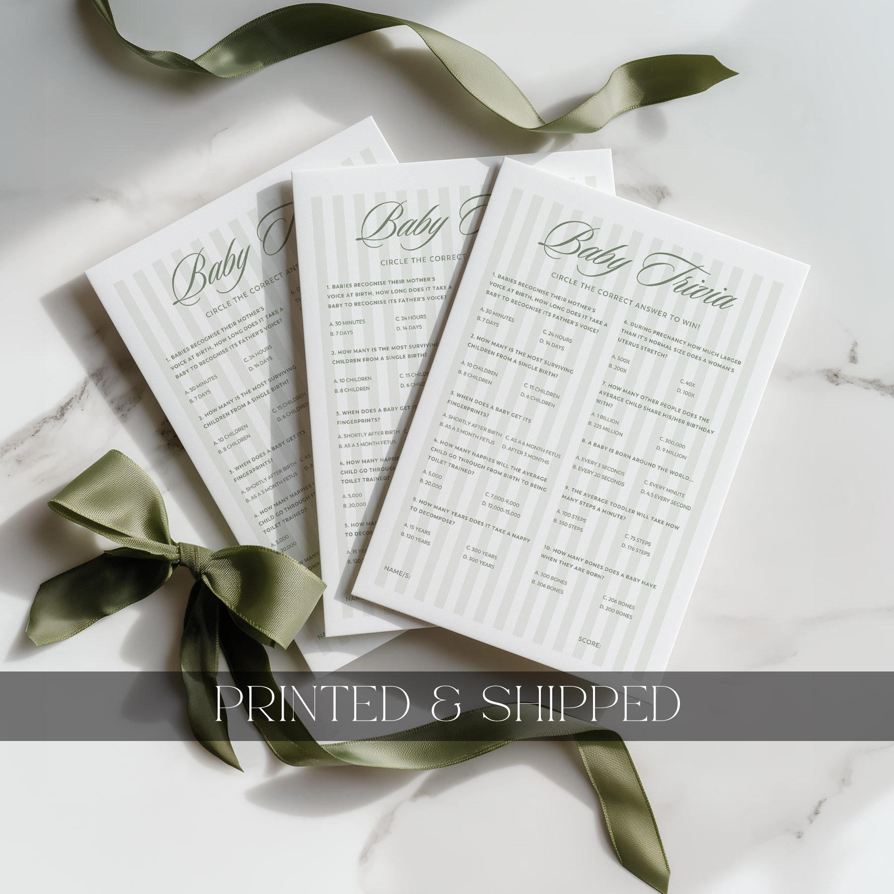 Three green stripe baby shower games with green ribbons on a white surface