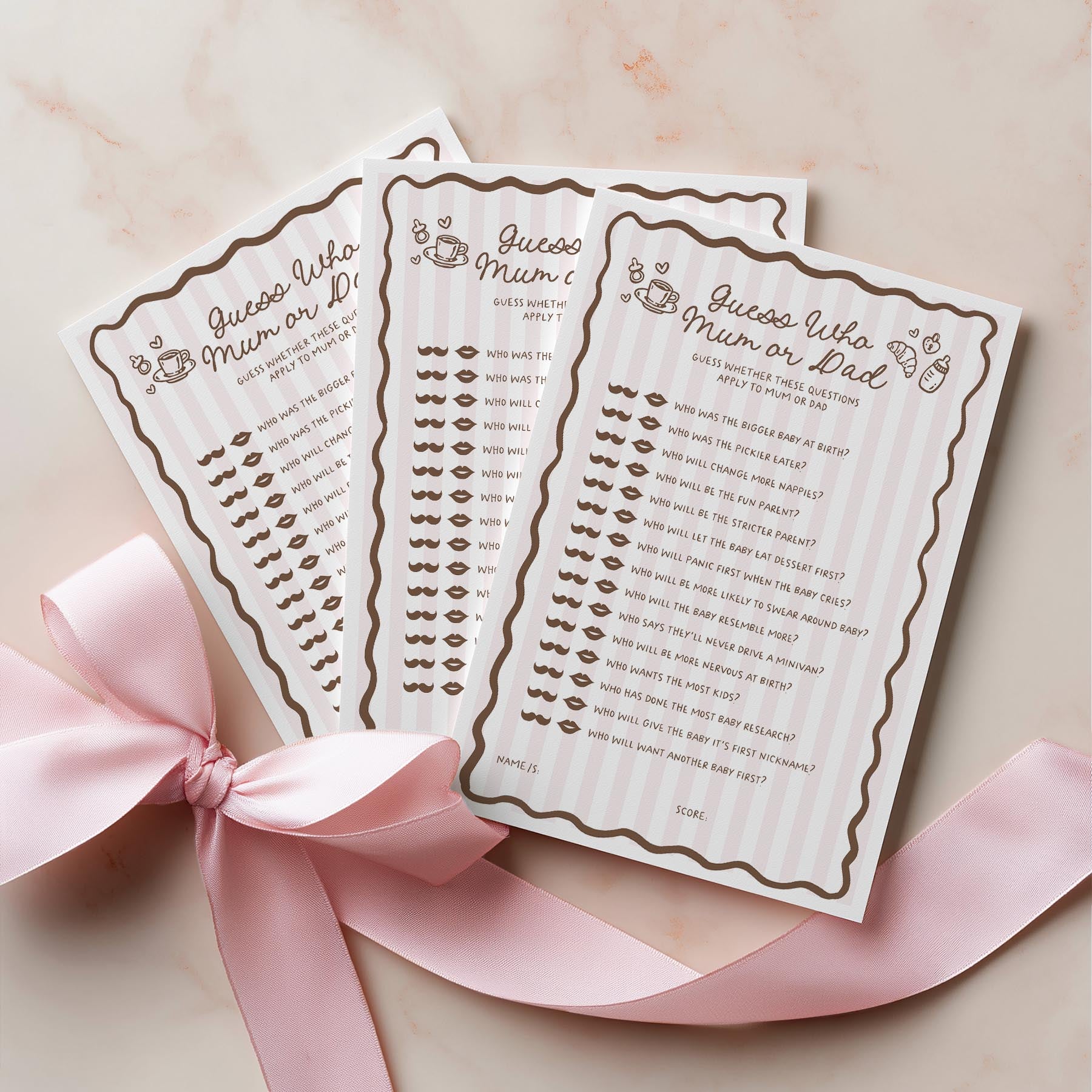 Two baby shower game cards with lip prints and a pink ribbon on a light background