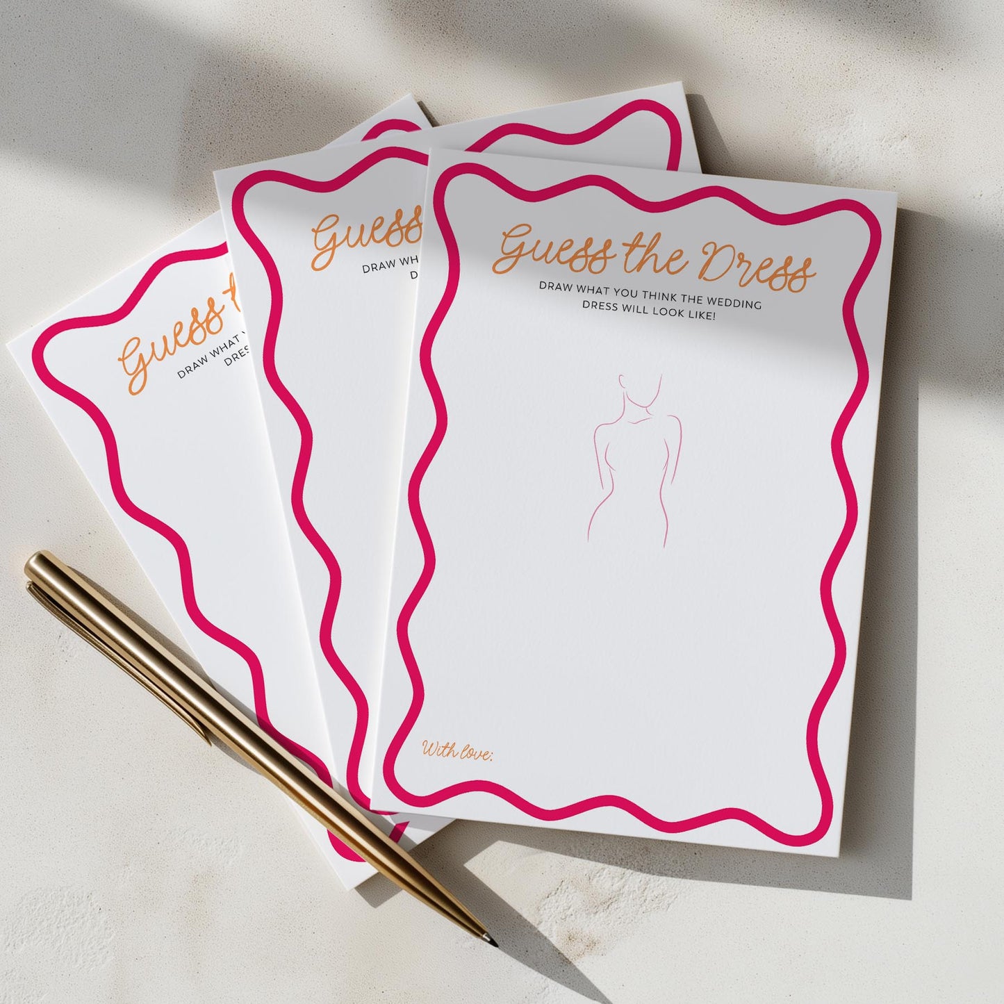 Three 'Guess the Dress' cards with a pen on a light surface
