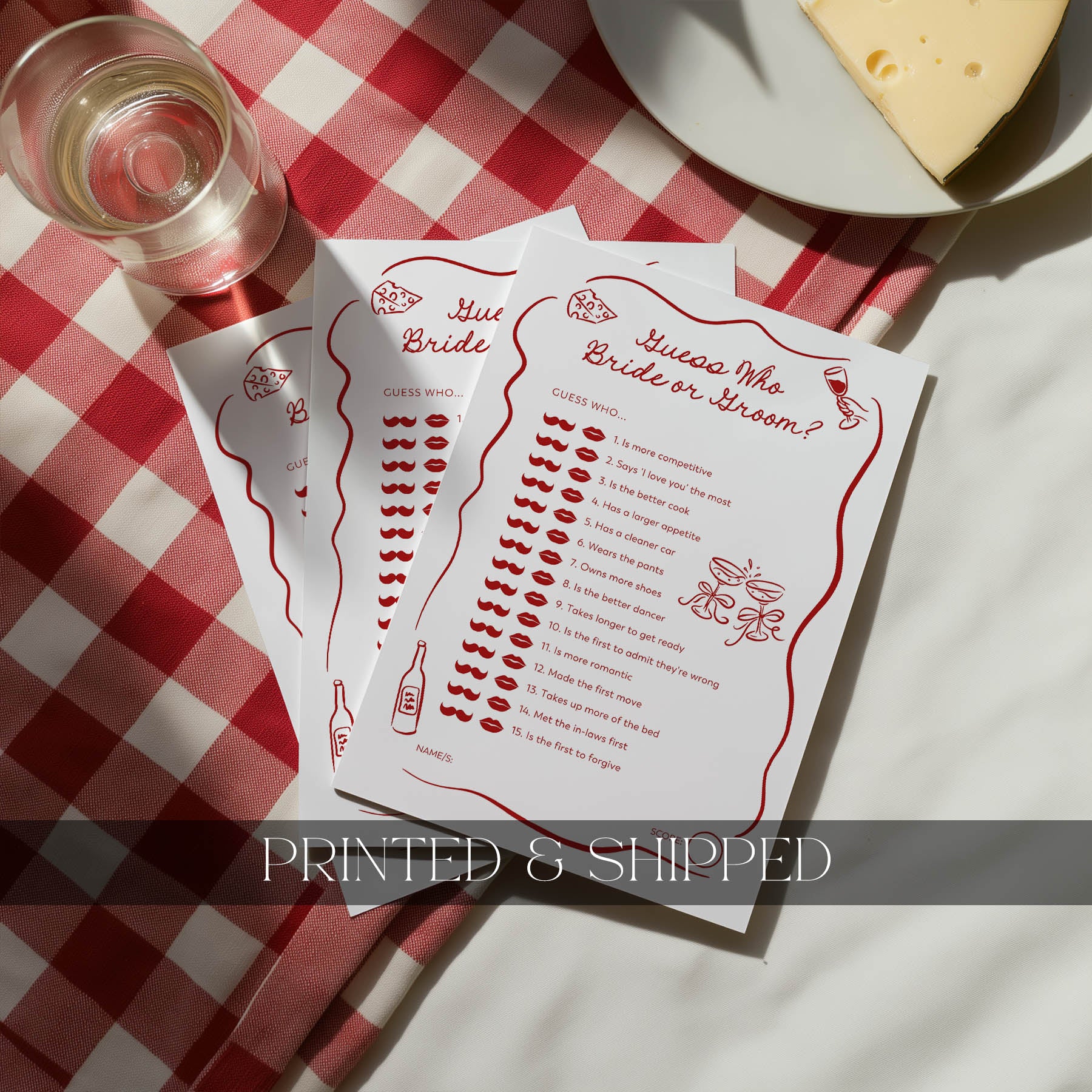 Printed bridal shower game cards on a table with wine and cheese.