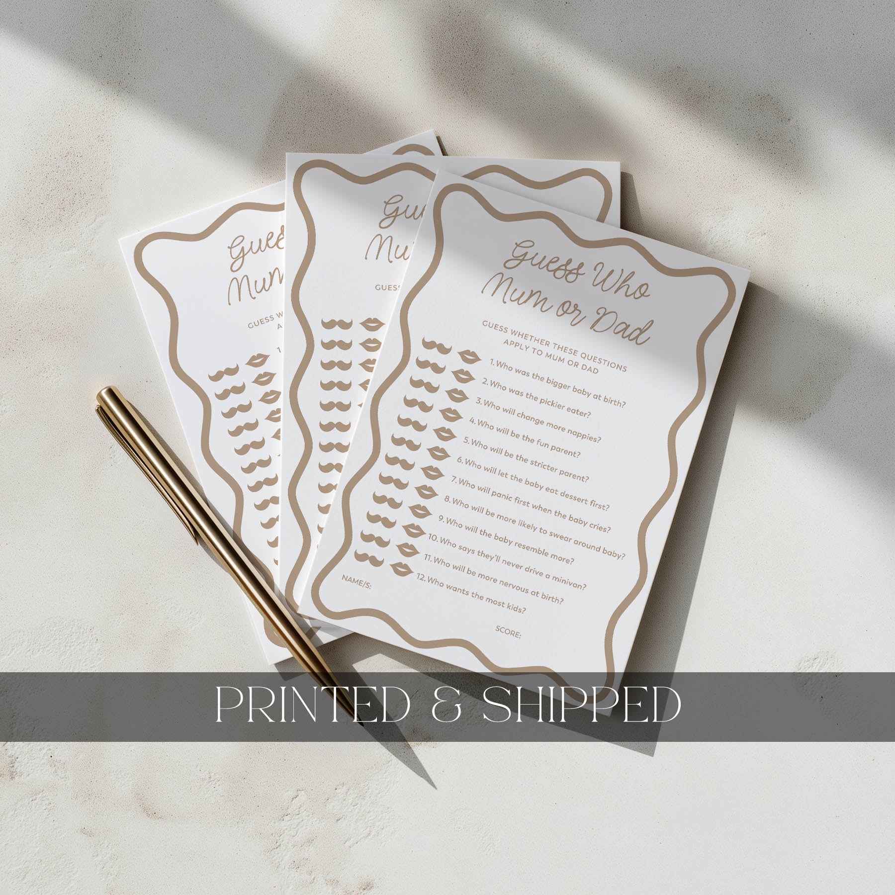 Two printed cards with gold text and a pen on a light surface.