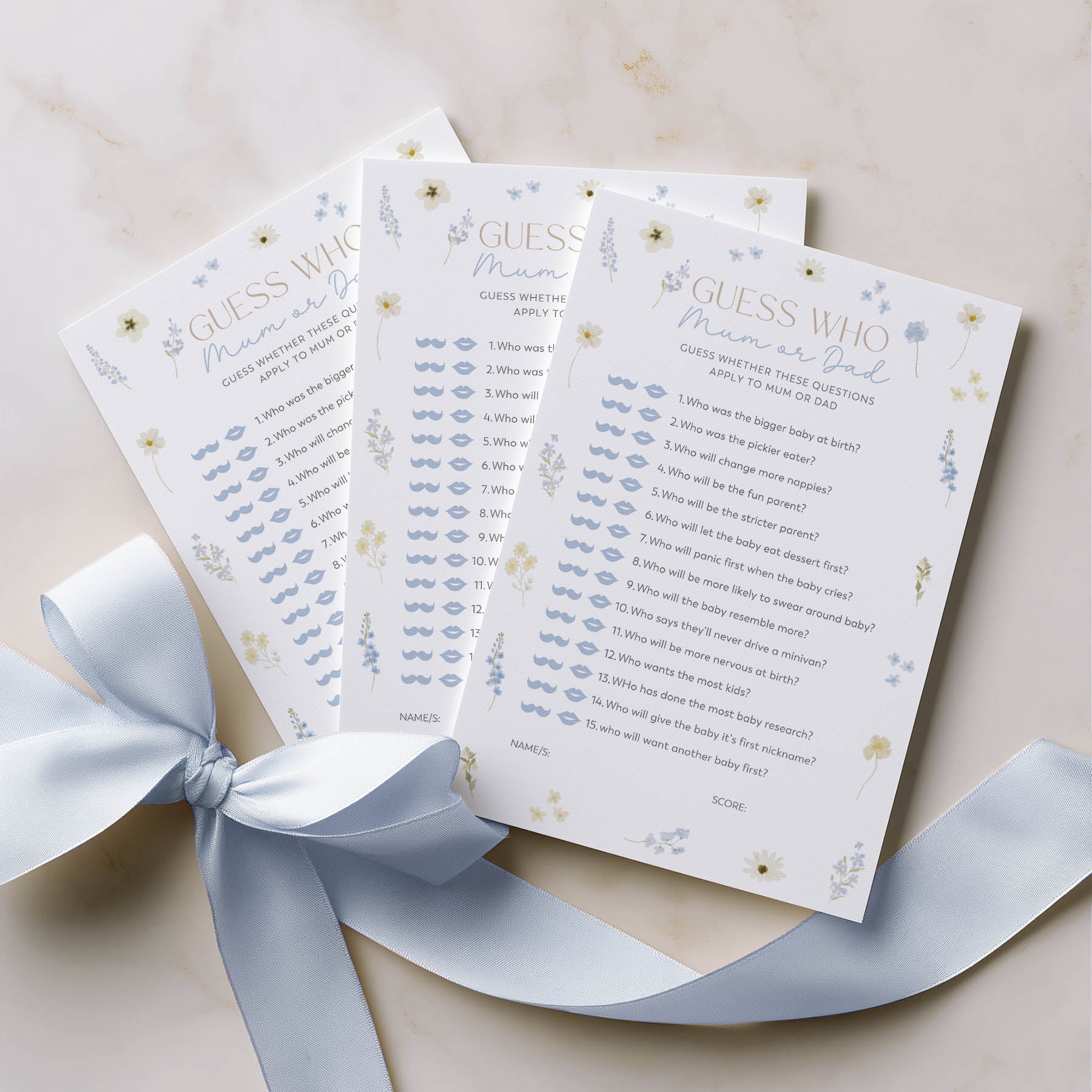 Three baby shower game cards with a blue ribbon on a light background