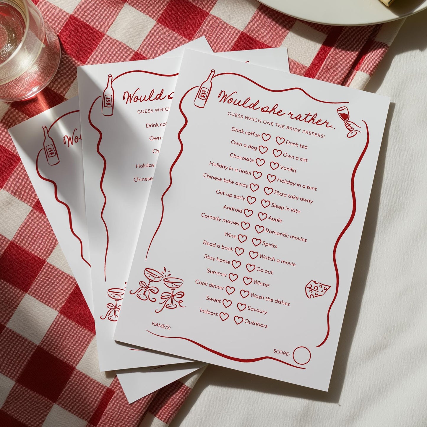White cards with red text and graphics on a red and white checkered tablecloth.