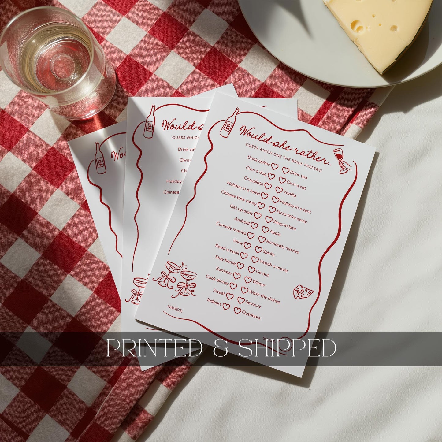 Three printed questionnaires on a red and white checkered tablecloth with a glass of wine and cheese.