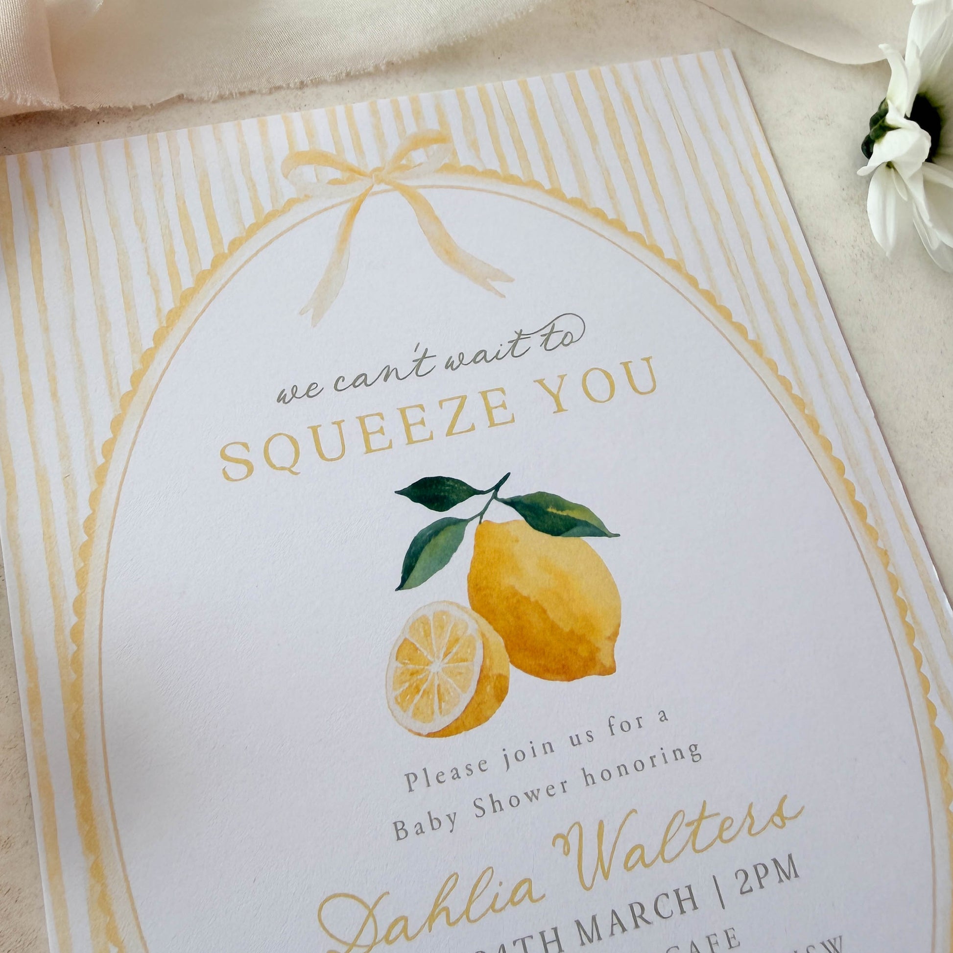Baby shower invitation with lemons and decorative text on a white background