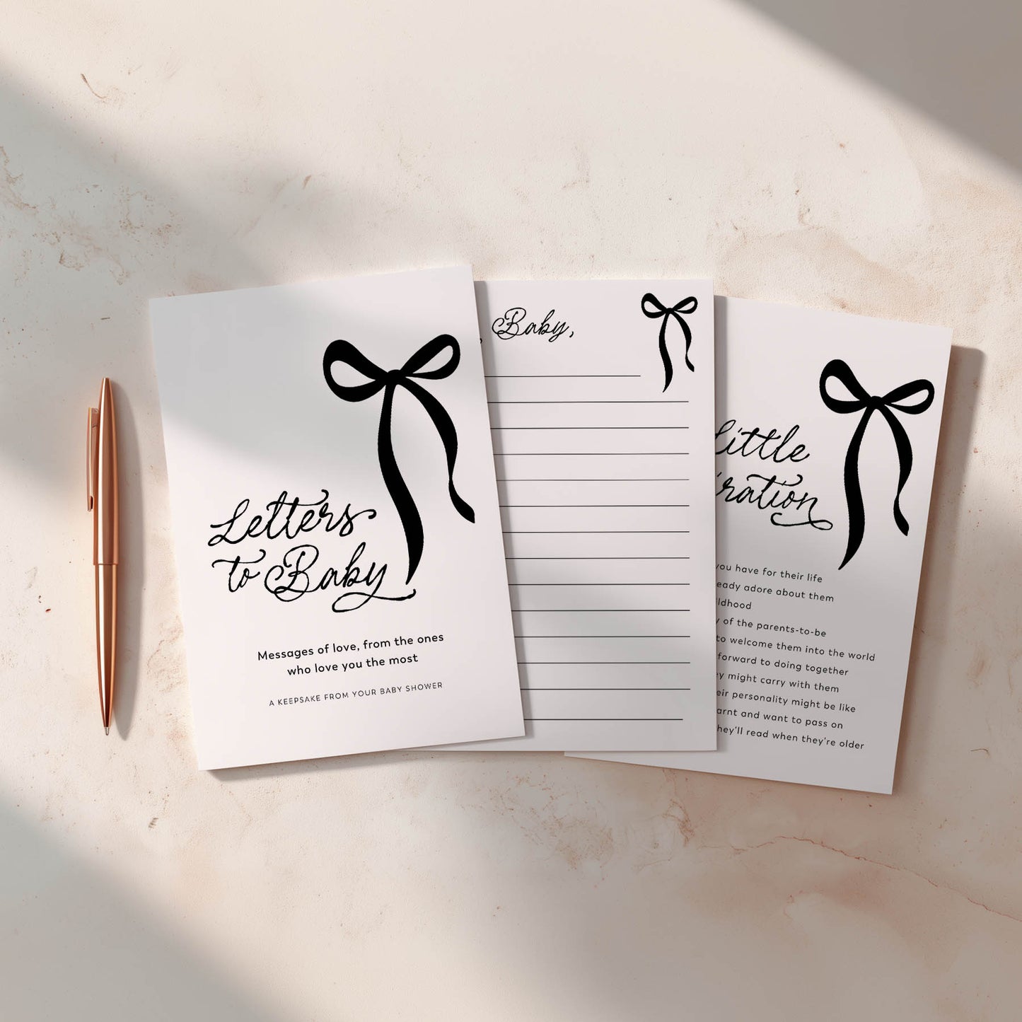 Baby Shower games with decorative black bows and text on a light surface with a pen.